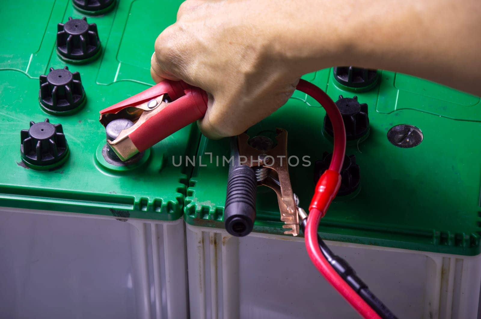 Top view, mechanic working with battery tweezers