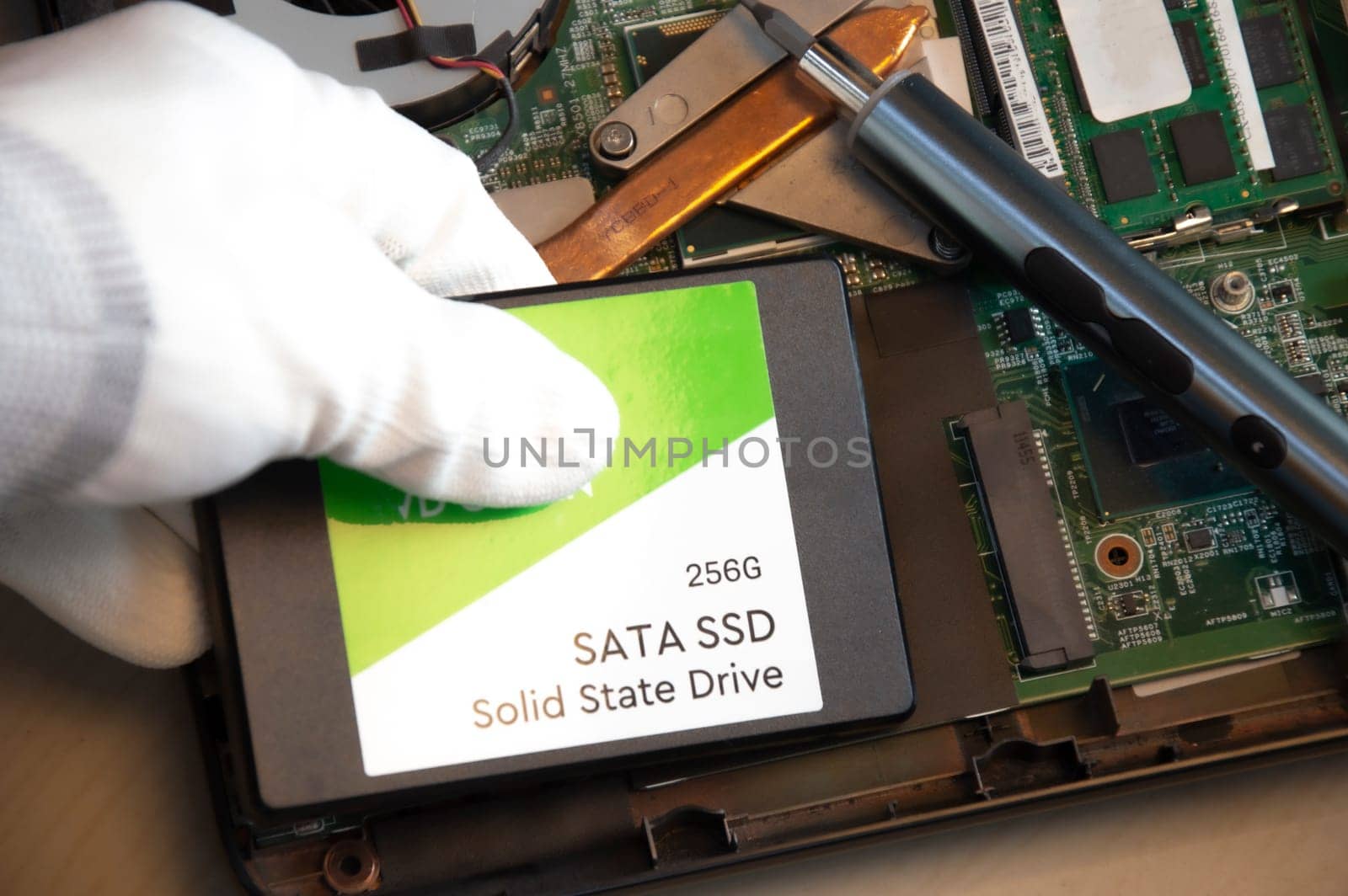 Technician installing ssd drive in old computer, upgrading computer