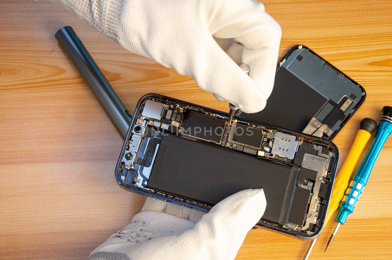 Top view of a technician repairing a smartphone by boonruen
