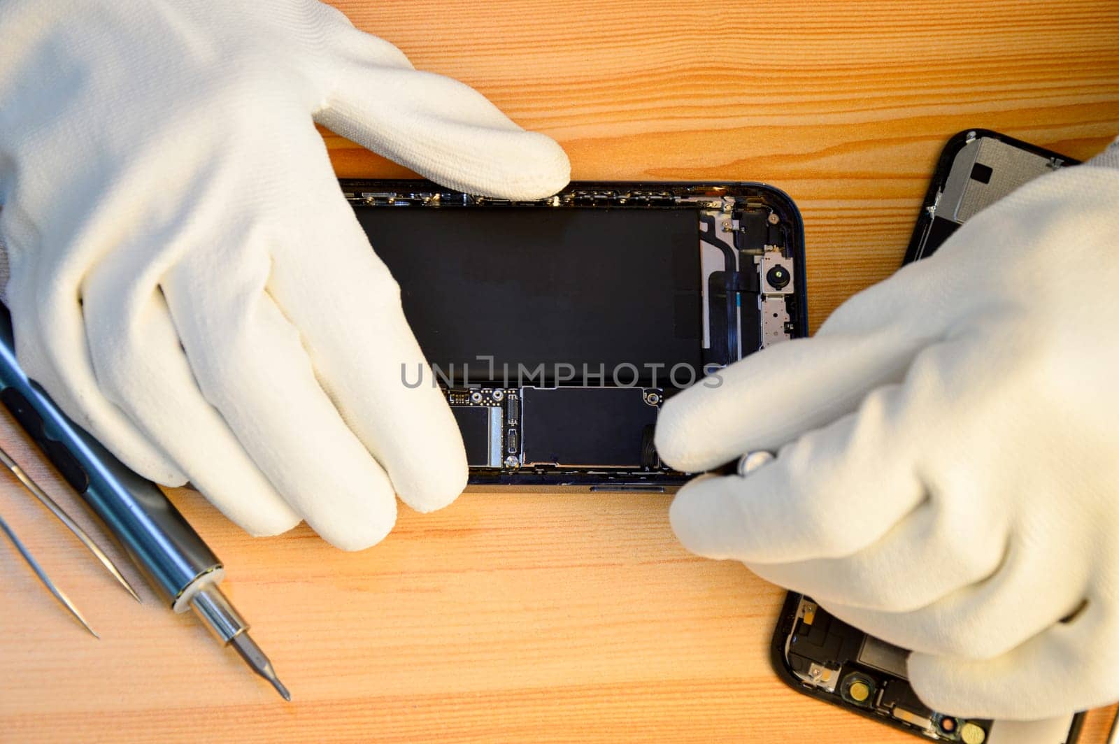 Top view of a technician repairing a smartphone