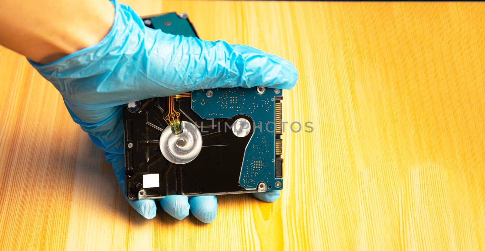 2.5 inch hard disk in hand with brown wooden background by boonruen