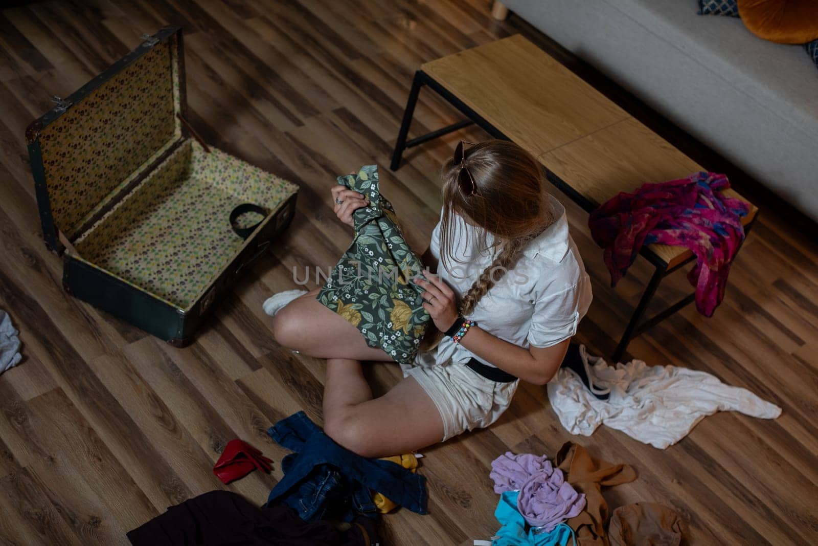 A young woman diligently sorting through a variety of colorful clothing while carefully organizing her fashion items
