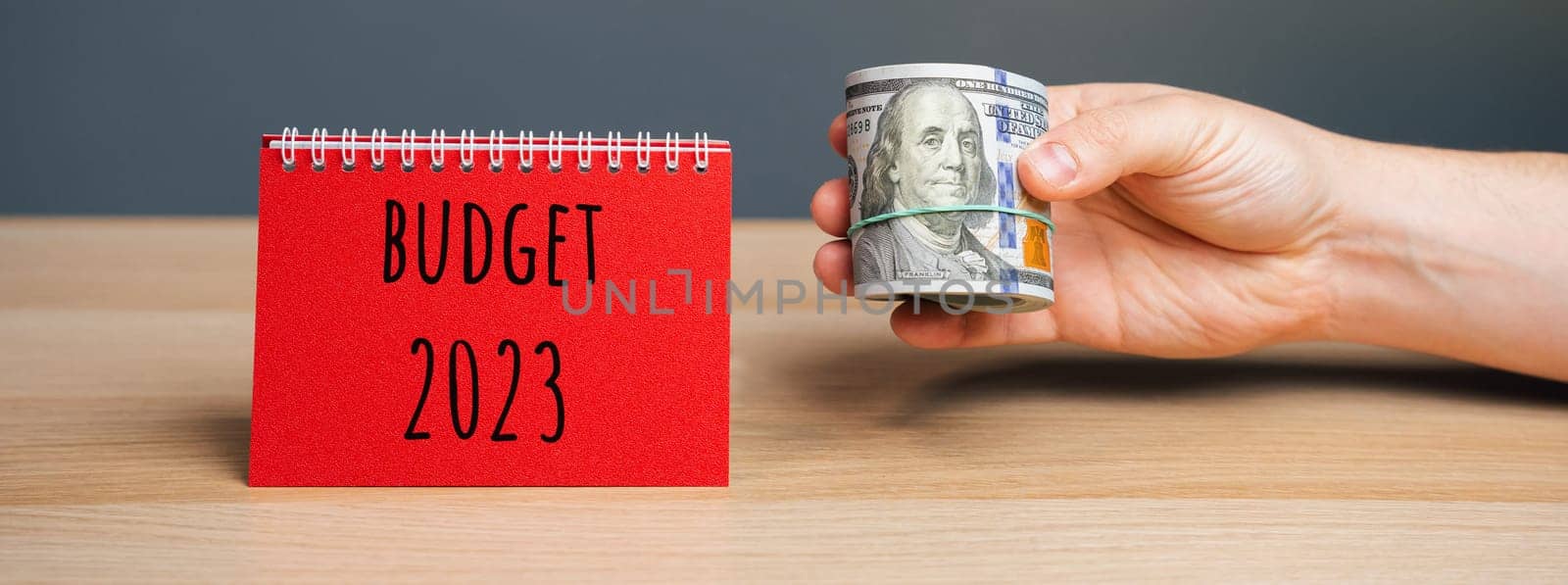 Budget 2023 concept. Financial management in company. Setting goal, target. Plans and tasks. Business and finance concept. Company's annual income statement. Note, dollars in the hand of a businessman