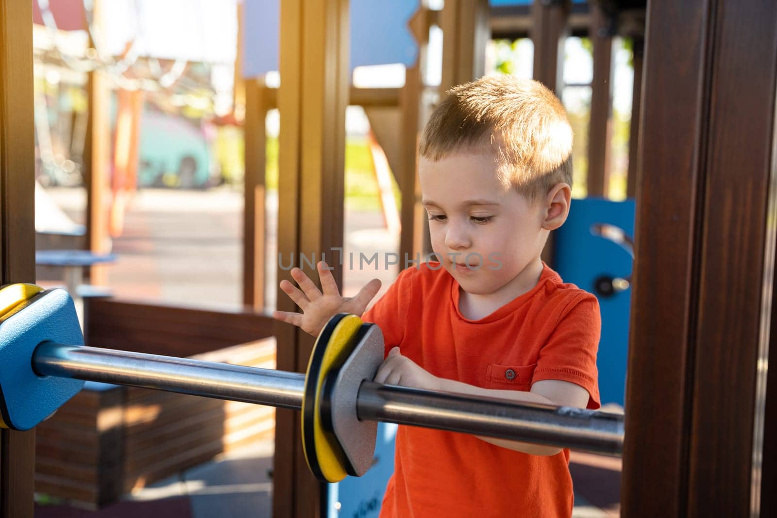 Cute toddler boy two or three years old is playing on the playground with colorful rings on a sunny summer day. Children's games. Close-up. Selective focus