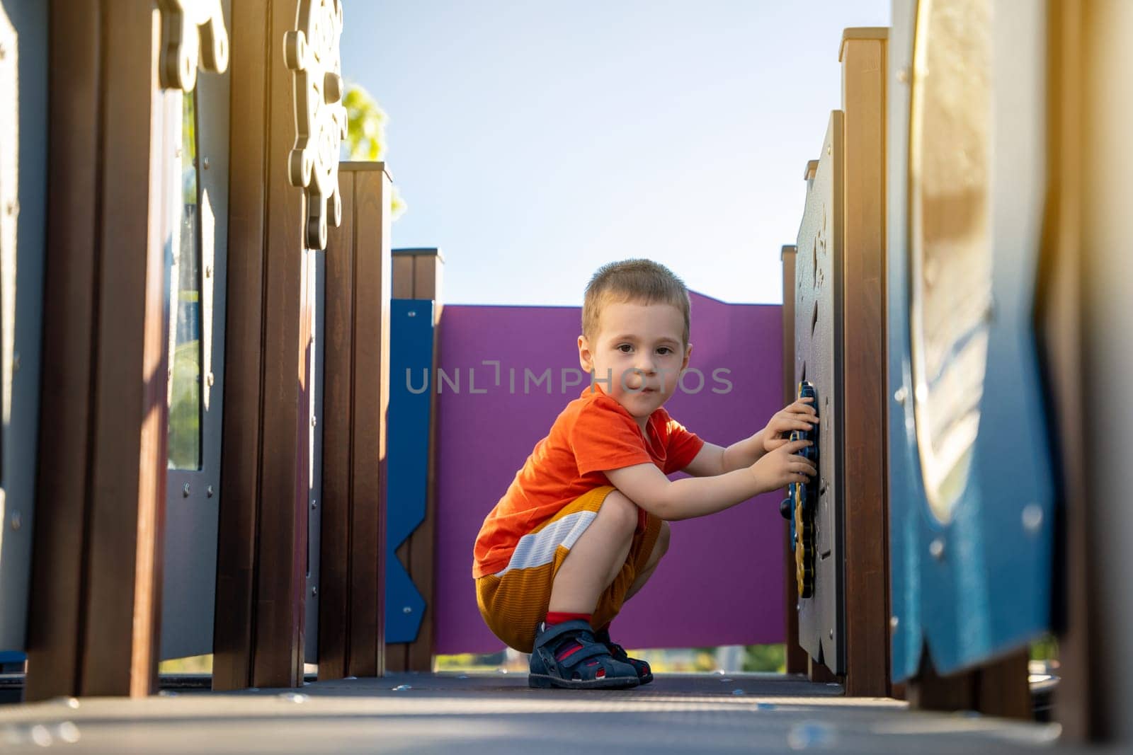 Cute toddler boy two or three years old is playing on the playground outside. Healthy summer activity for children. Children's games. Selective focus