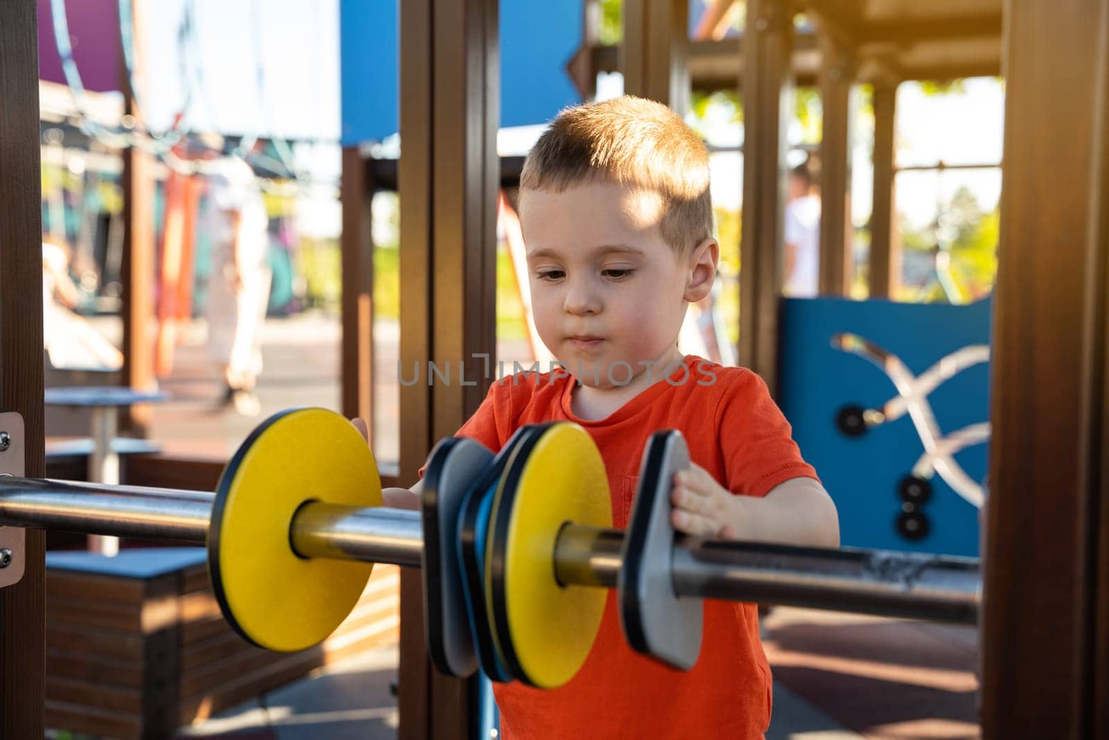 Cute toddler boy two or three years old is playing on the playground with colorful rings on a sunny summer day. Children's games. Close-up. Selective focus