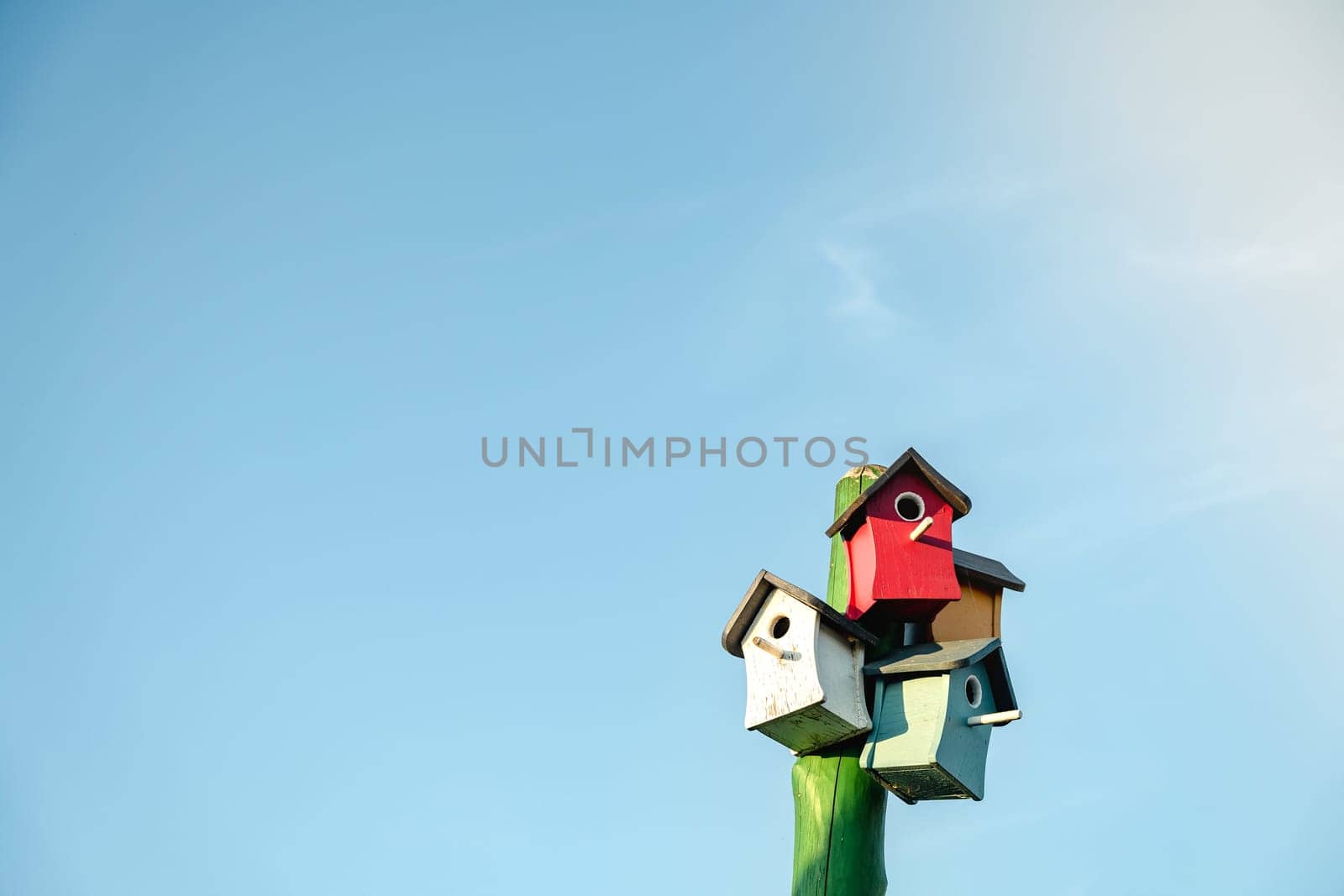 Wooden small bird houses and birdhouses against the blue sky. Real estate and affordable housing concept. Mortgage, loan, taxes. Buying, selling and renting apartments. Copy space