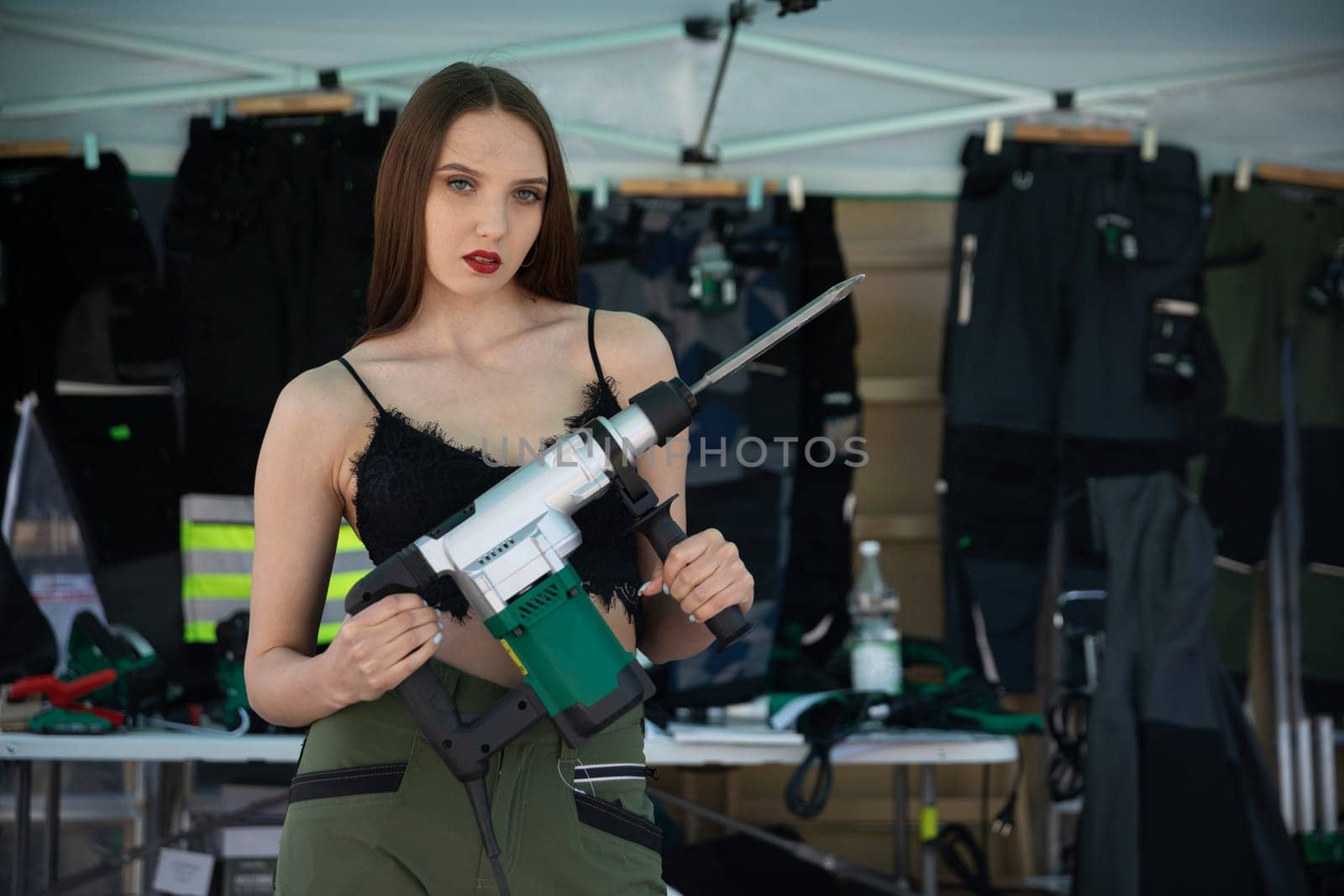 A confident model elegantly showcases striking and fashionable equipment against a vibrant fashion backdrop