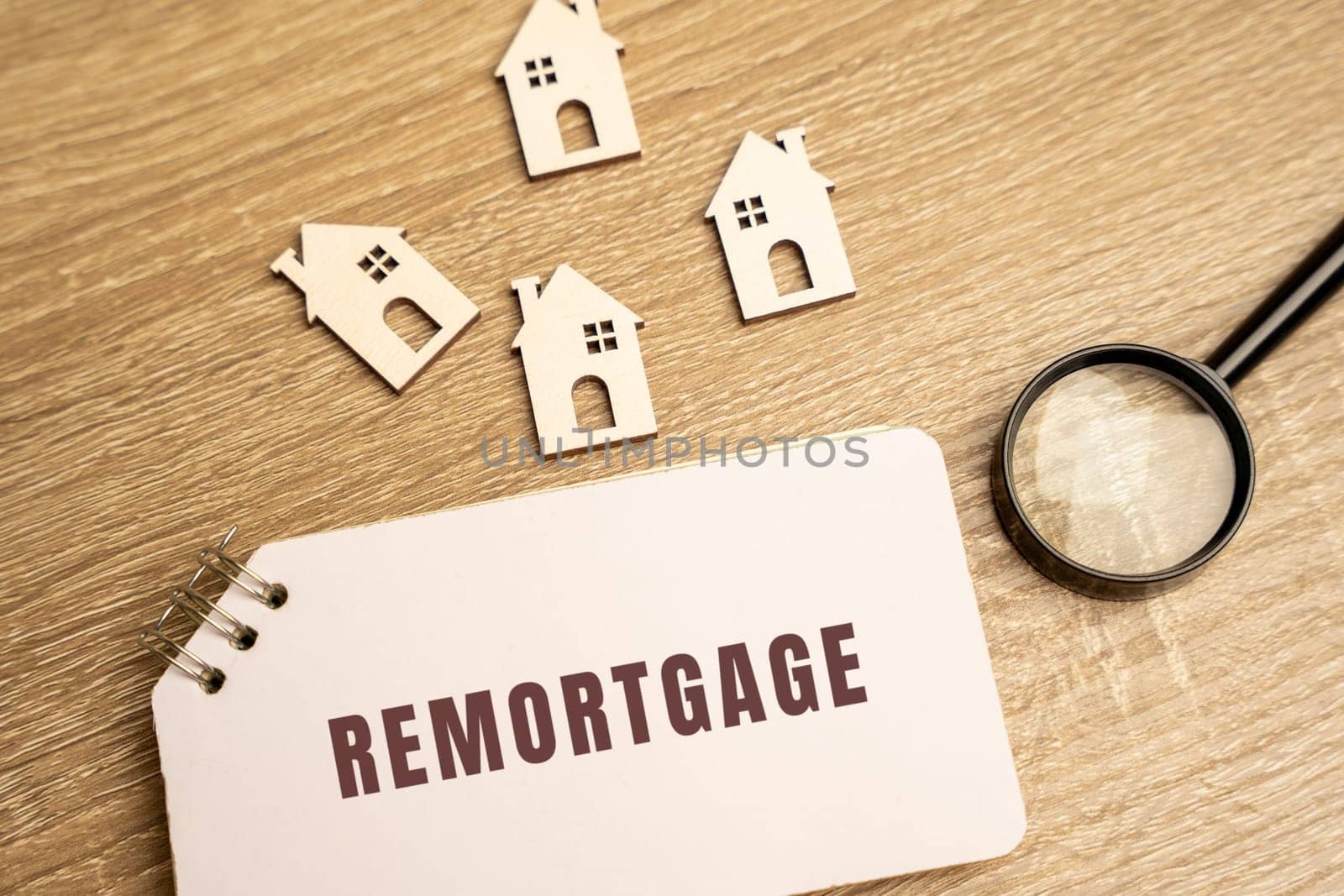Remortgage concept. Process of paying off your mortgage with the proceeds from a new mortgage using the same property as security. wooden houses on the table and notes