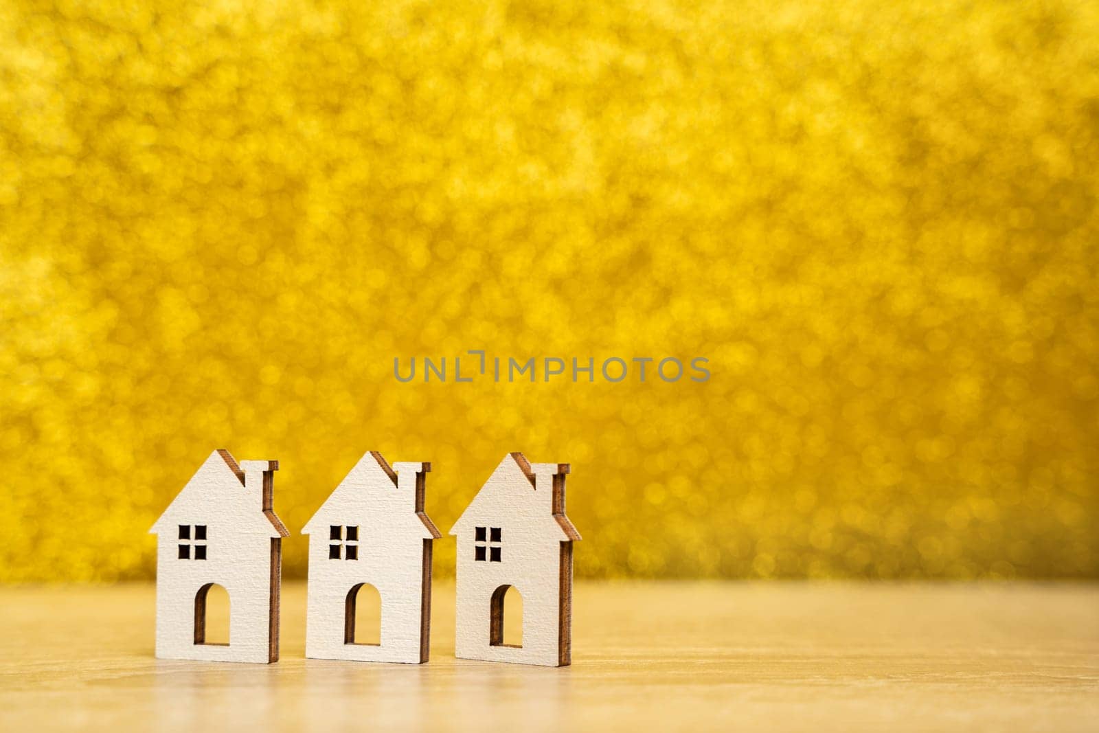 Wooden houses on a yellow background. Real estate and affordable housing concept. Mortgage, loan and insurance of apartments. Selling and buying home. Copy space