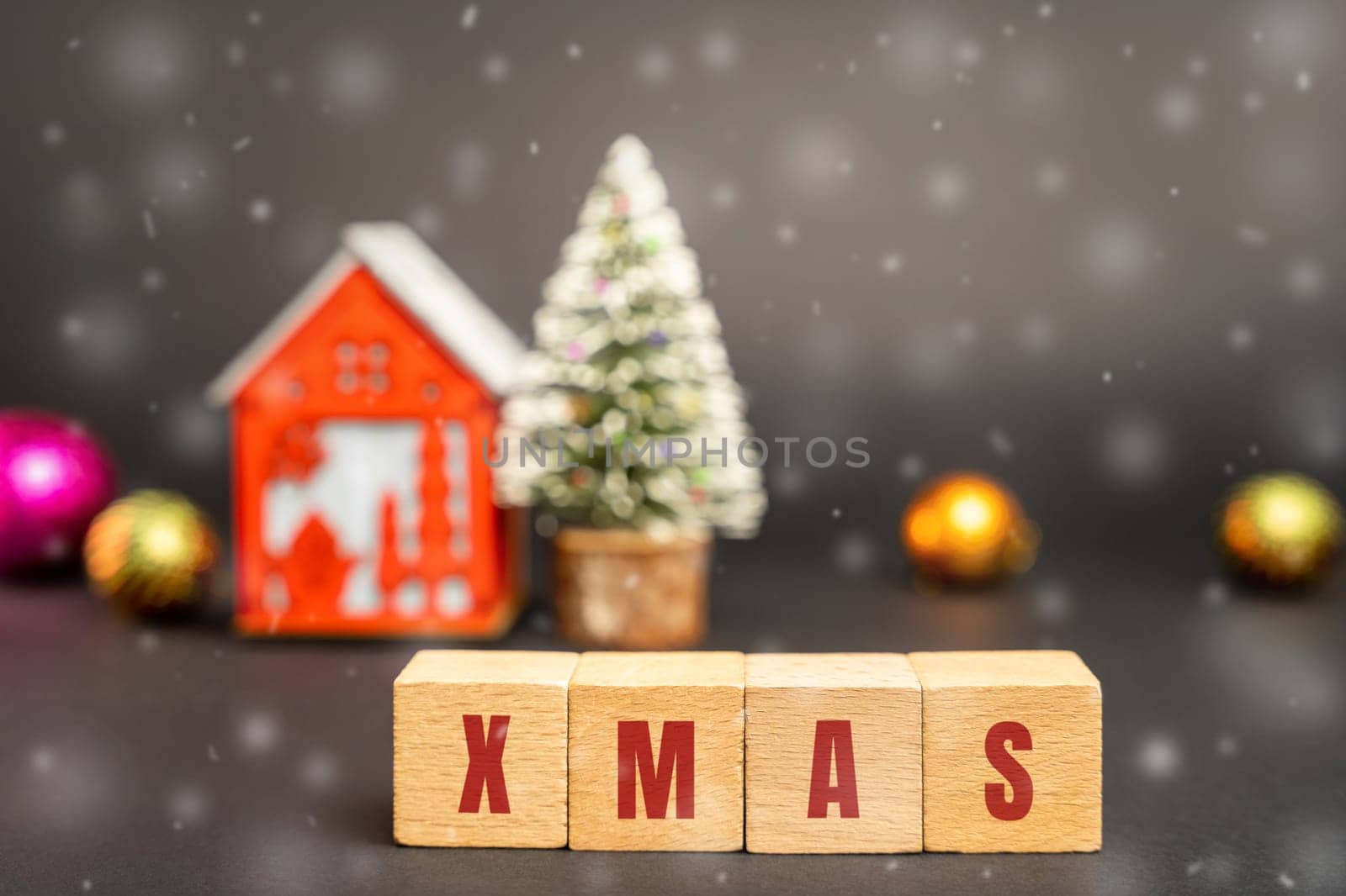 Wooden blocks with the word Xmas, miniature house and a Christmas tree. New Year or Xmas winter holiday. Decoration, celebration. The concept of the beginning of the new year. Snow, snowfall