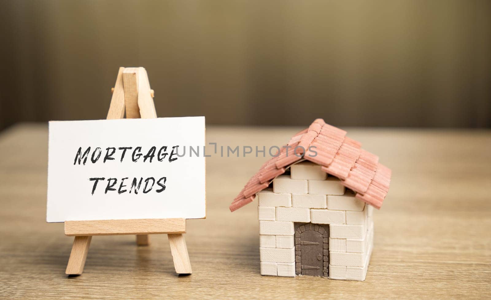 Easel with Mortgage trends concept and a miniature house. Mortgage rates and the latest news about their changes. Housing loan and real estate. Business and finance