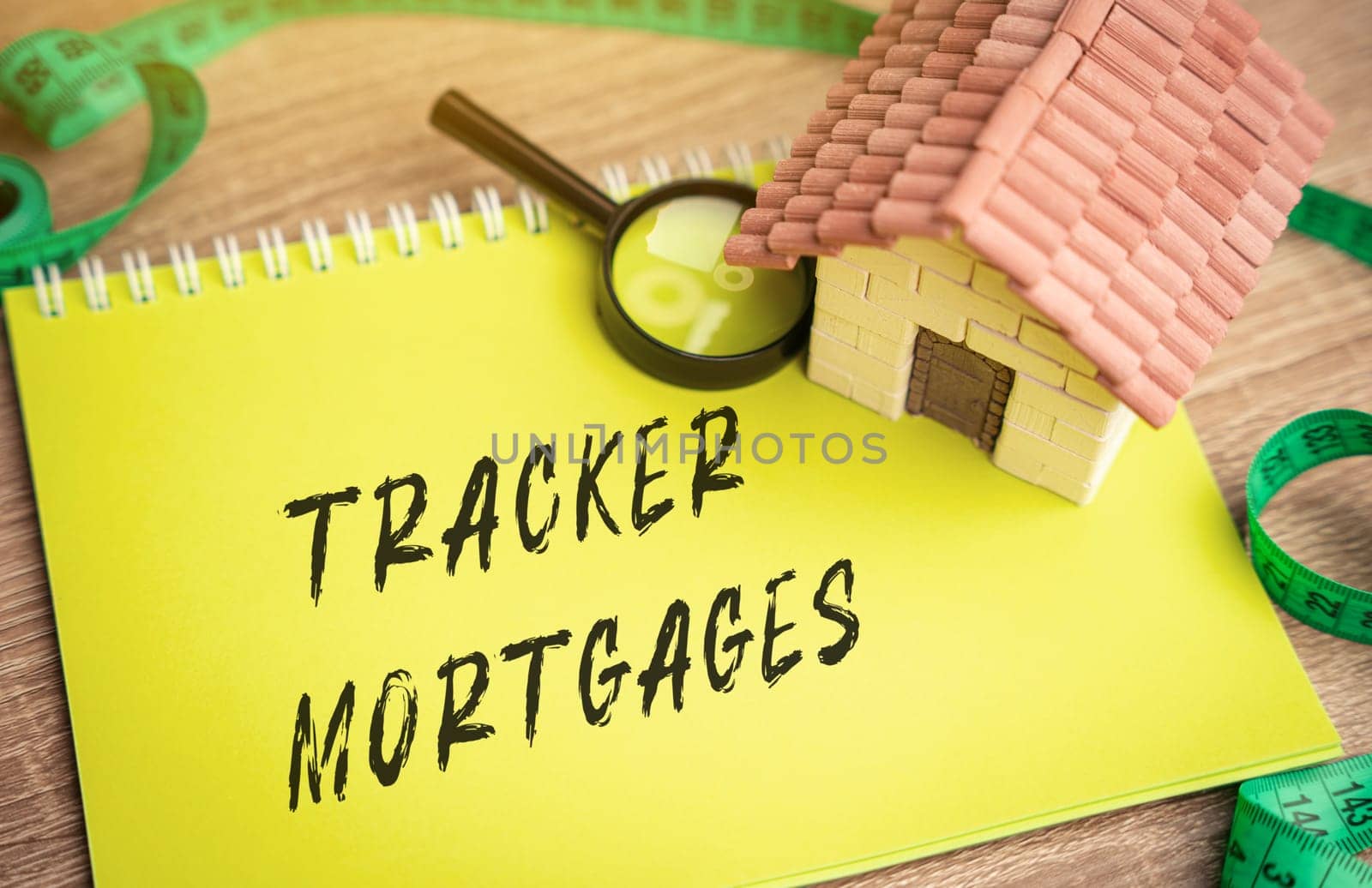 Tracker mortgages concept - home loan where the interest rate you pay is based on an external rate. Housing lending, real estate and finance concept. Miniature house and magnifying glass