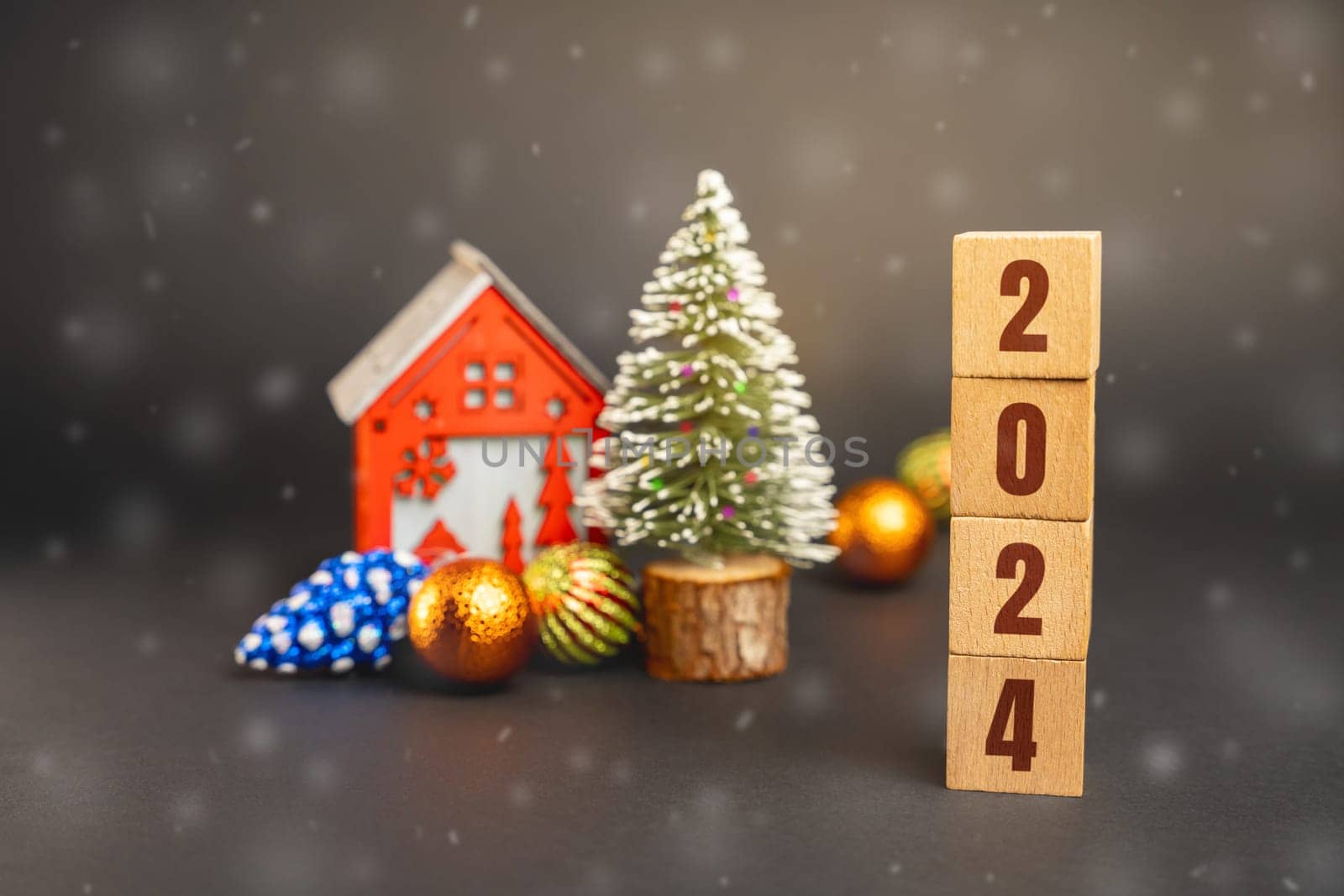 Blocks 2024, Christmas tree and red house. Merry Christmas and Happy New Year! Xmas concept. Festive winter holiday. Snowfall