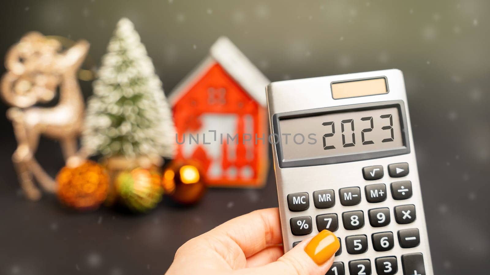 Calculator 2023, Christmas tree and miniature houses. Accumulating money and report. Business and finance. Loans, deposit, credit. Promotions, offers.
