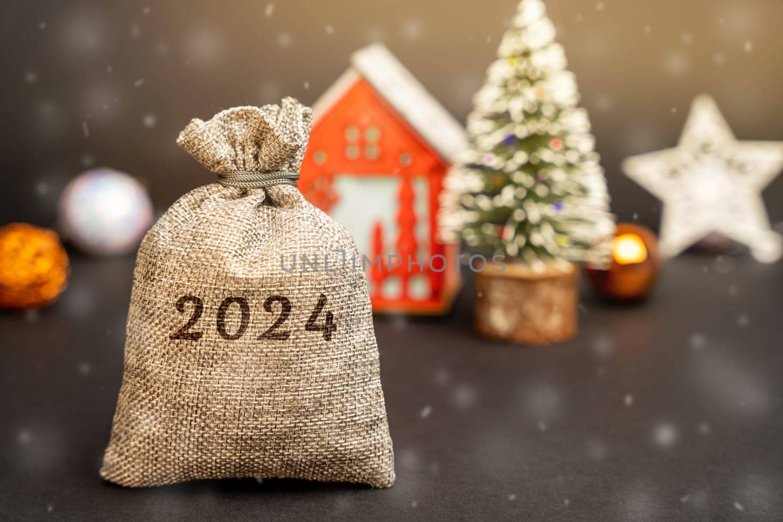 Money bag 2024, Christmas tree and red house. Merry Christmas and Happy New Year! Xmas concept. Accumulating money and planning a budget. Business and finance. Loans, deposit, credit.
