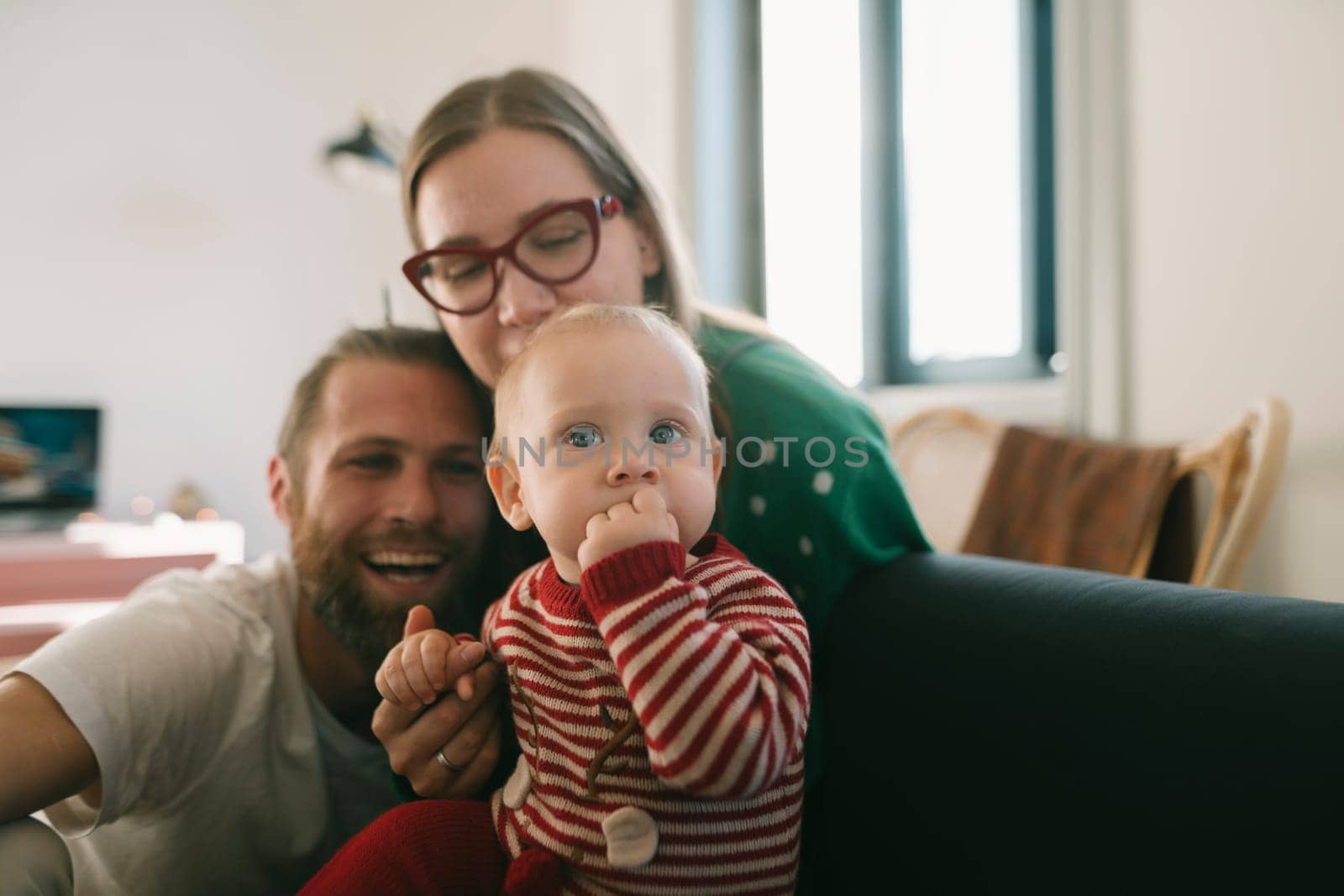 A wonderful and joyful family moment that showcases happy parents cherishing their baby, creating lasting memories