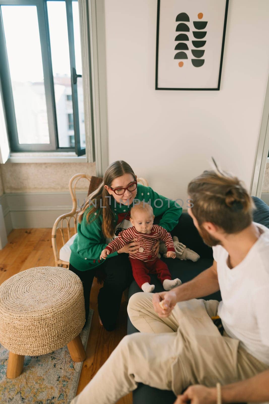 A loving family sharing a delightful and warm moment together with their adorable baby in a stylish home setting