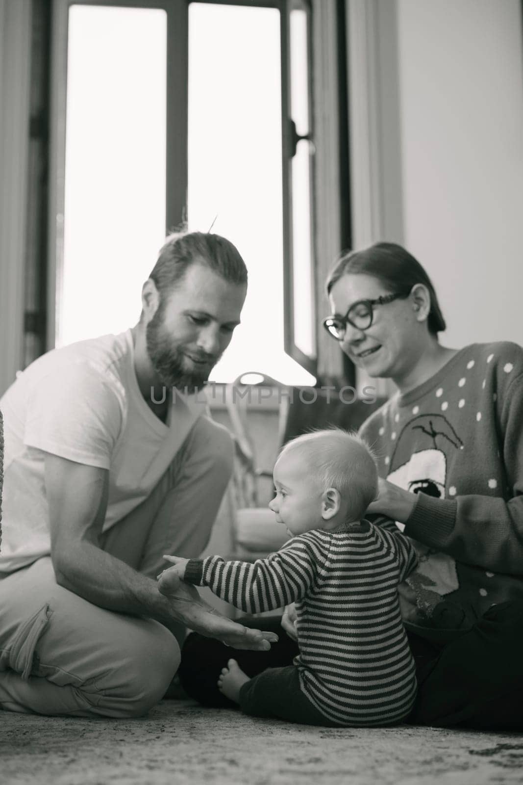 A heartwarming family scene showcasing a baby enjoying precious moments with loving parents in a cozy indoor space