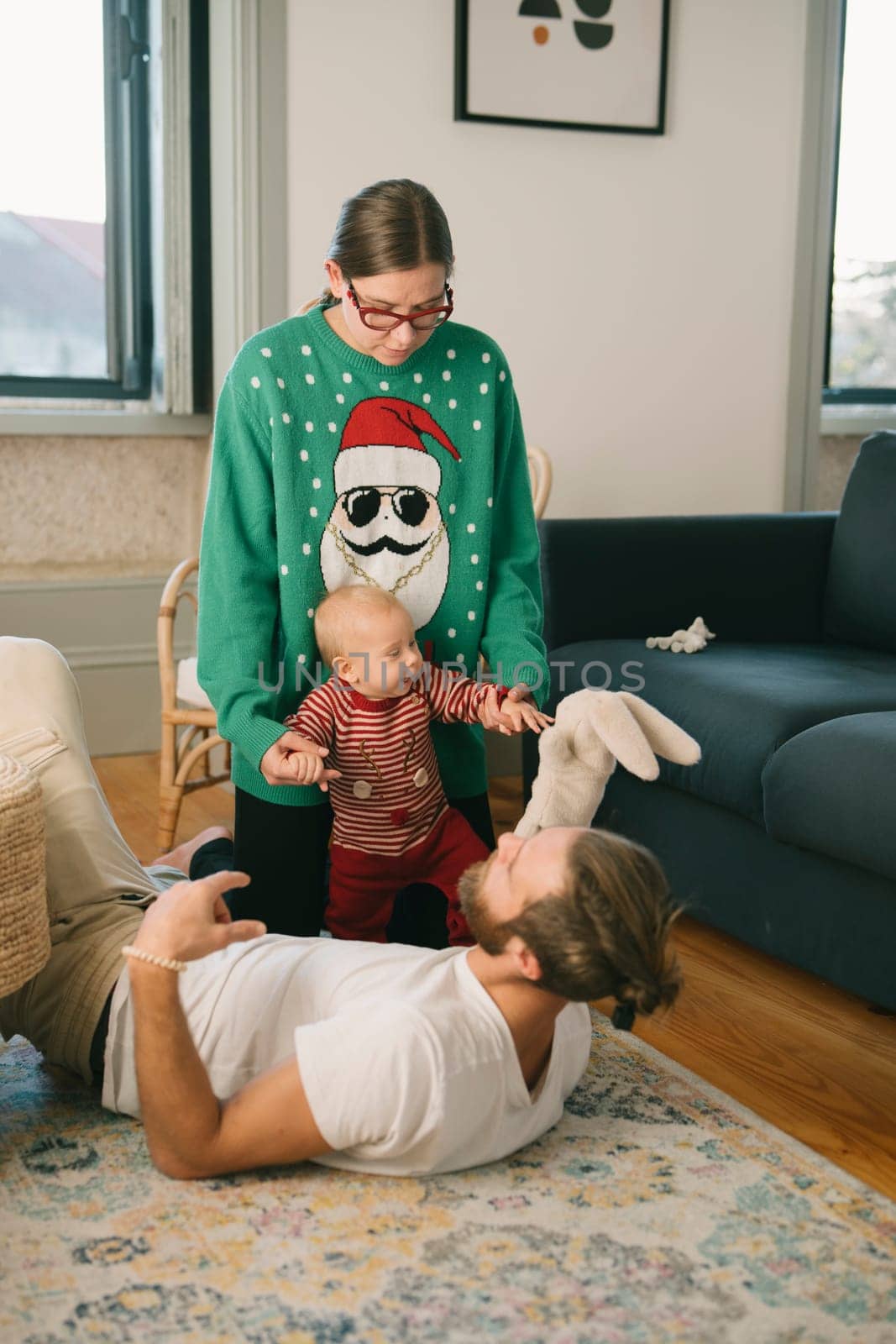 A joyous and heartwarming family moment filled with playful interactions and festive outfits in a cozy living room