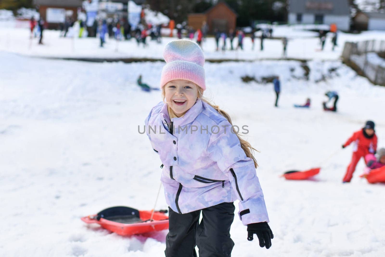 A girl with bob sledding in the snow in the mountains