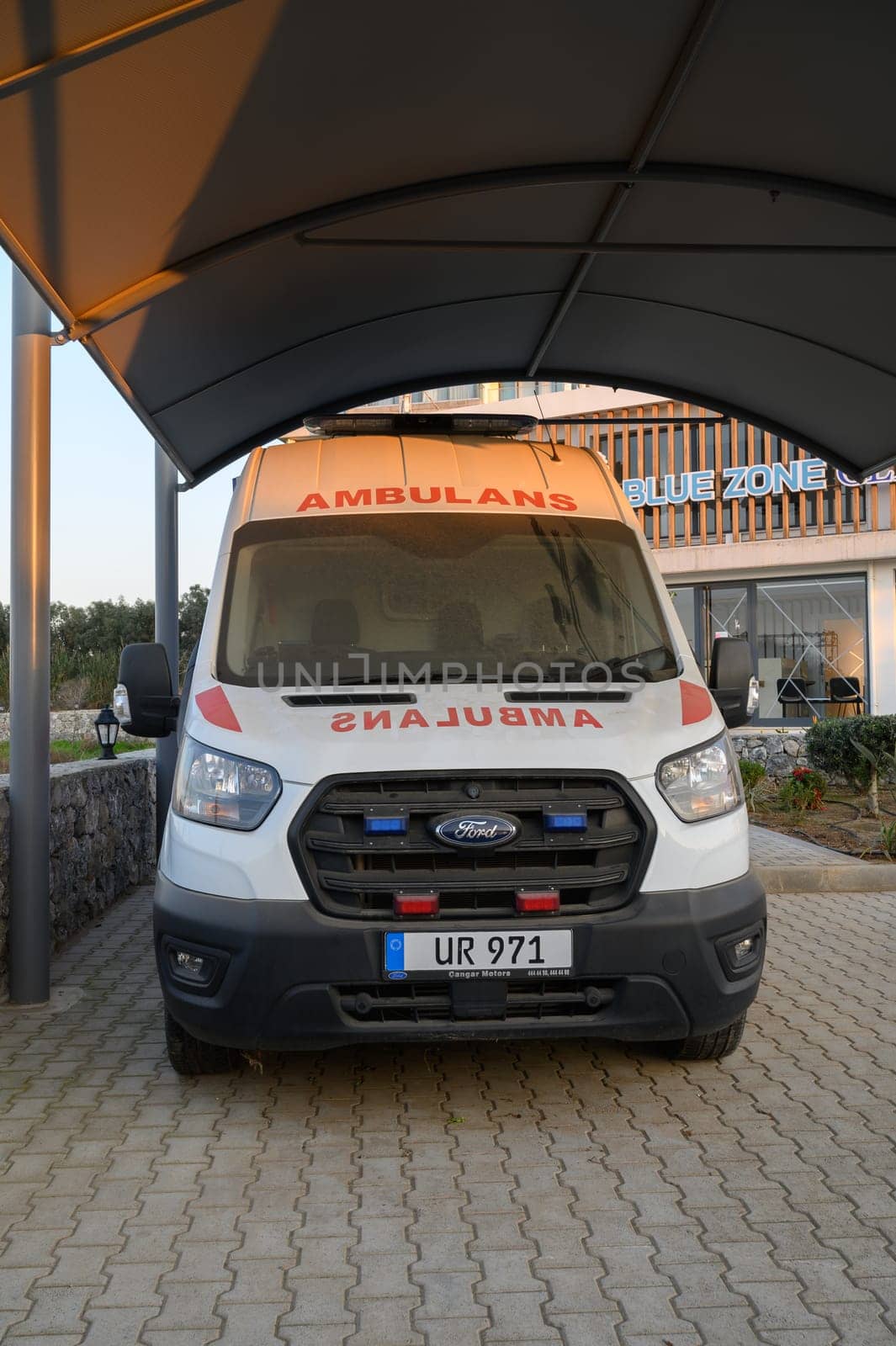 Gaziveren Cyprus -30.01.2025 An ambulance rests under a shelter at dusk, awaiting its next call for assistance in a serene environment.