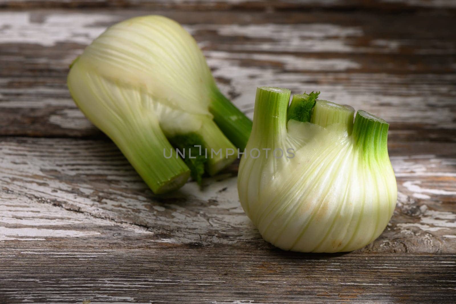 Organic fennel bulb sits beautifully on a weathered wood table, highlighting its unique shape and fresh hue.