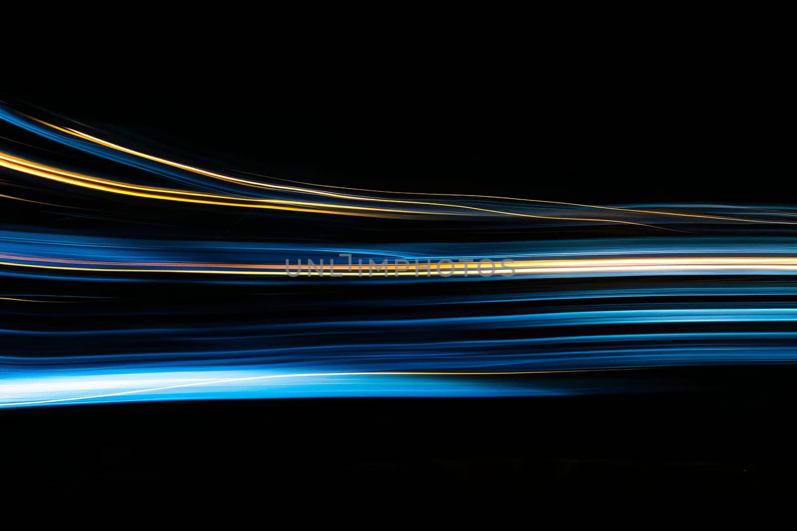 Abstract light trails in motion on a black background.