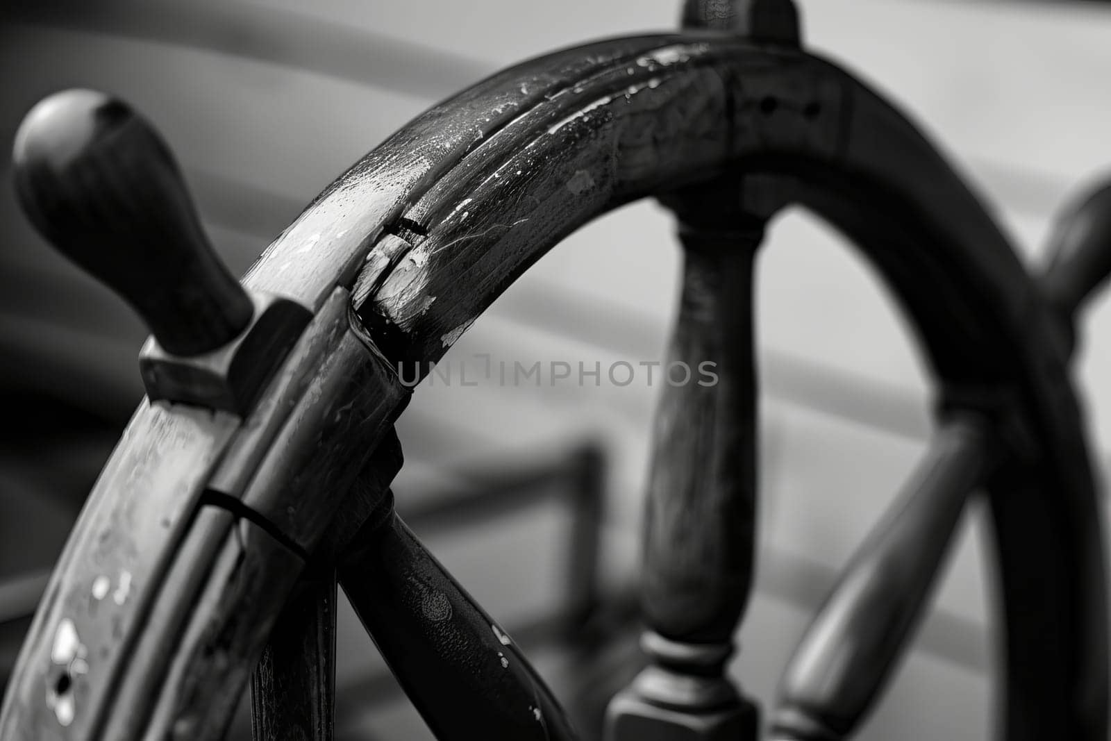 Close-up of vintage wooden ship's wheel with detailed texture in black and white.