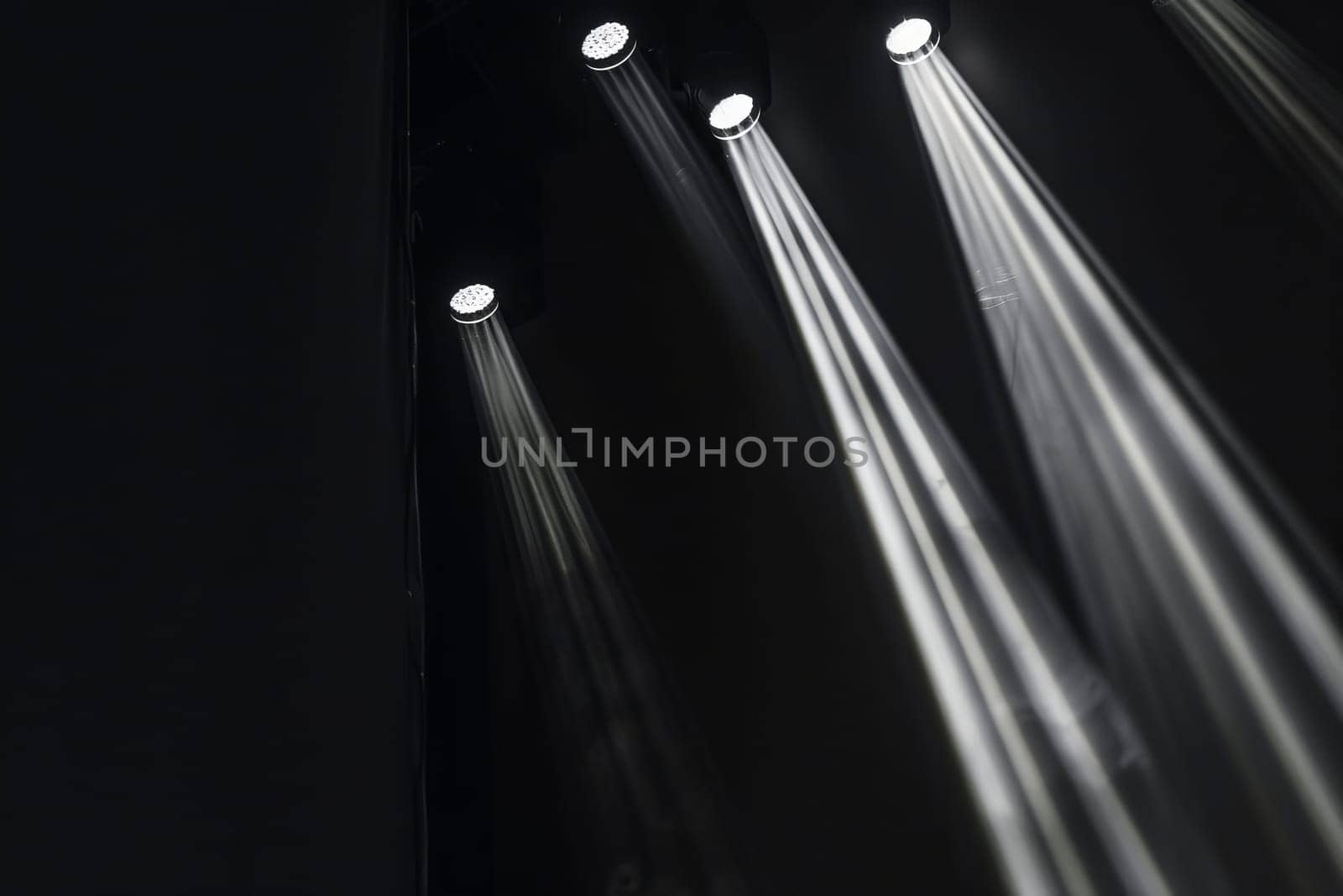 Dramatic stage lights illuminating dark theater scene.