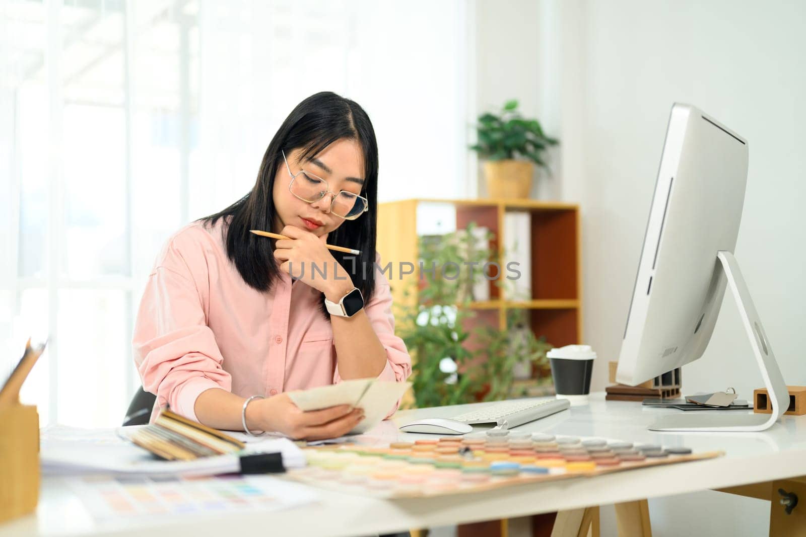 Female designer focused on selecting colors and materials home renovation project.
