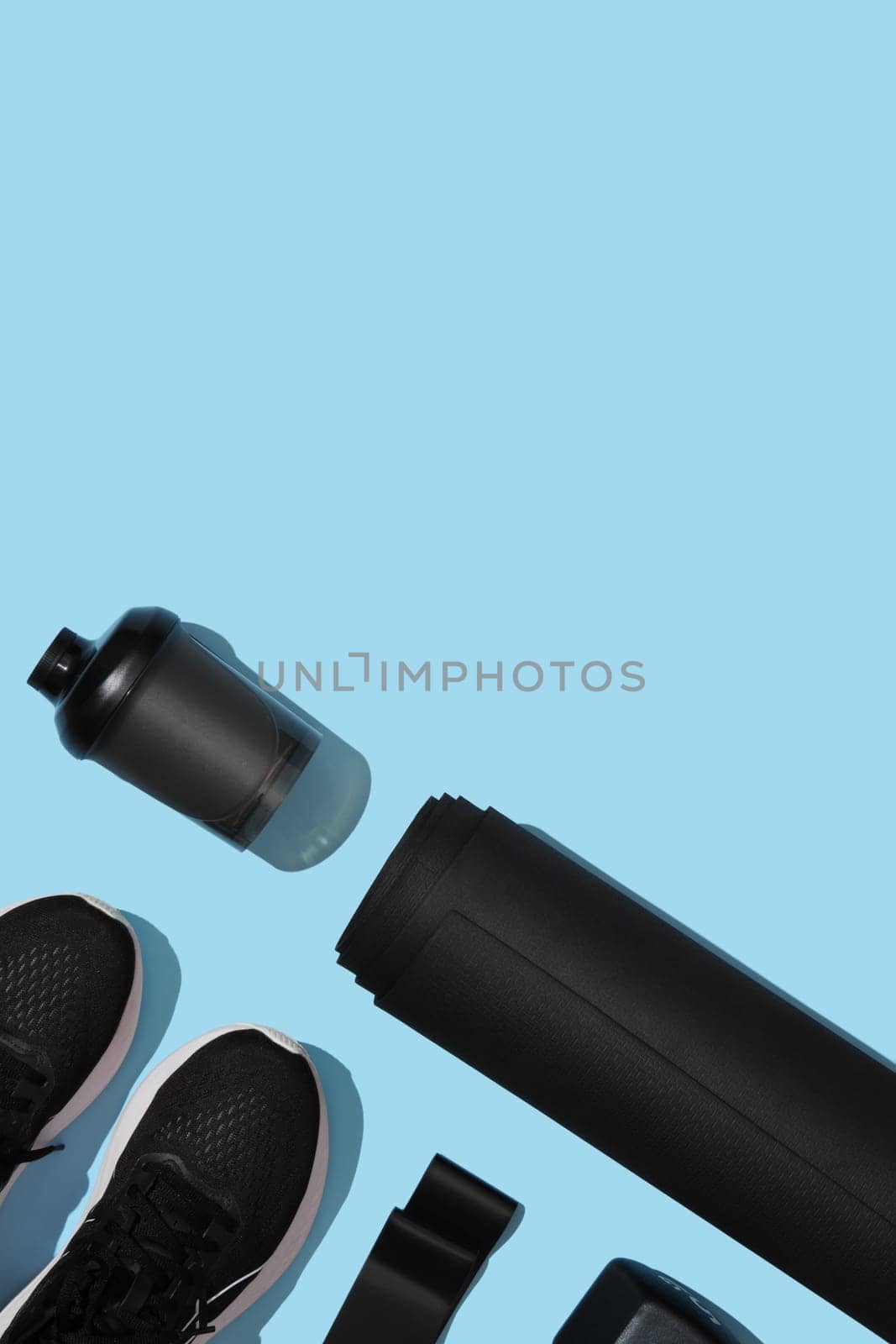 Black workout equipment for training at home on blue background. Fitness, sport items, healthy lifestyle concept. Copyspace