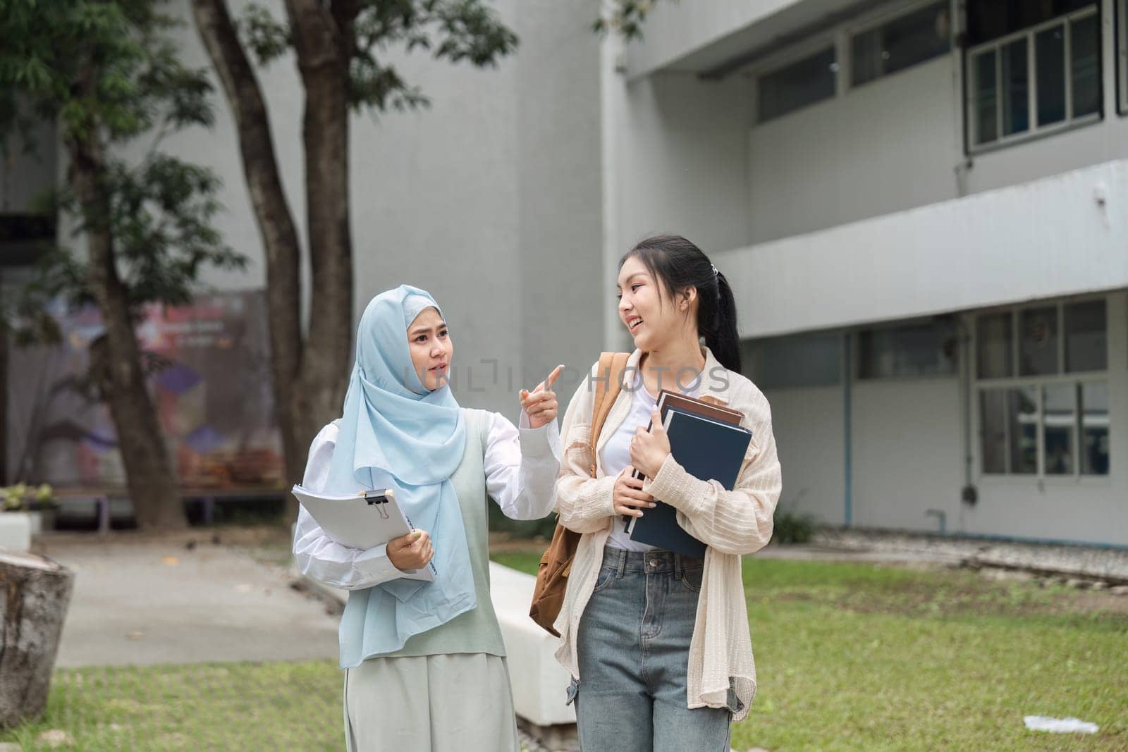 Two diverse university students animatedly discussing a topic while walking together on campus, showcasing friendship and academic camaraderie.