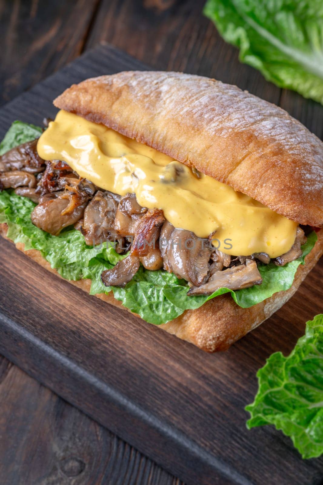 Delicious vegetarian sandwich with toasted ciabatta, fried oyster mushrooms, and yellow sauce