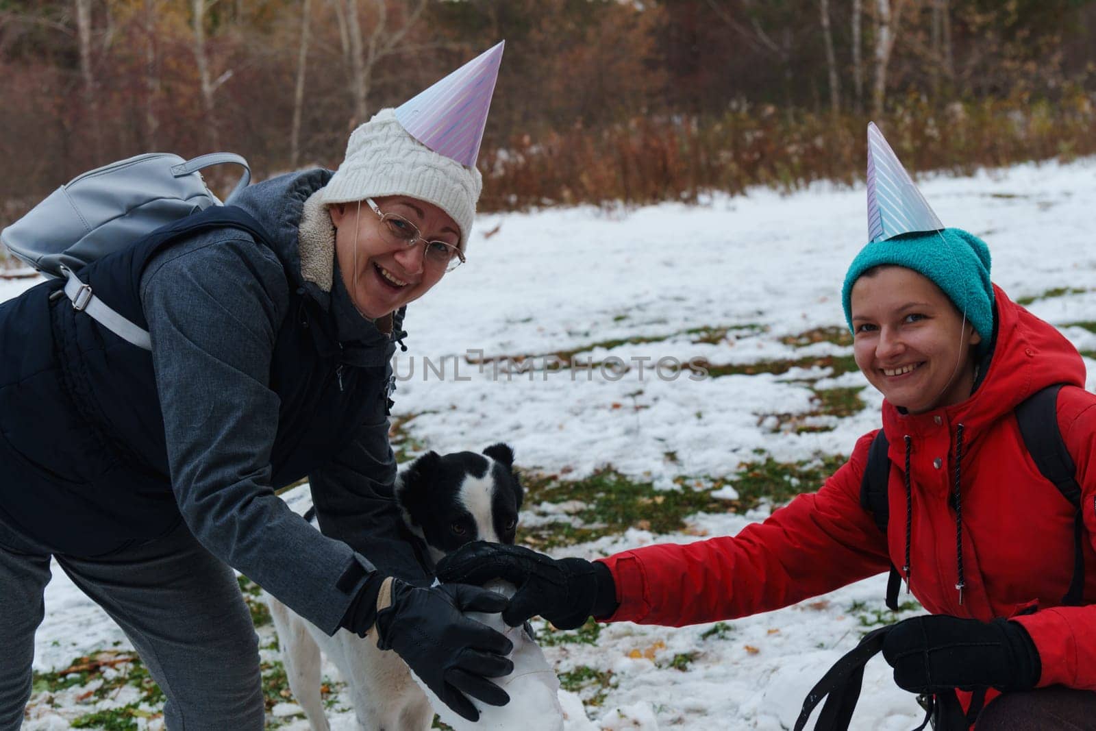 Joyful moments creating a snowman with friends in a snowy park during winter celebrations