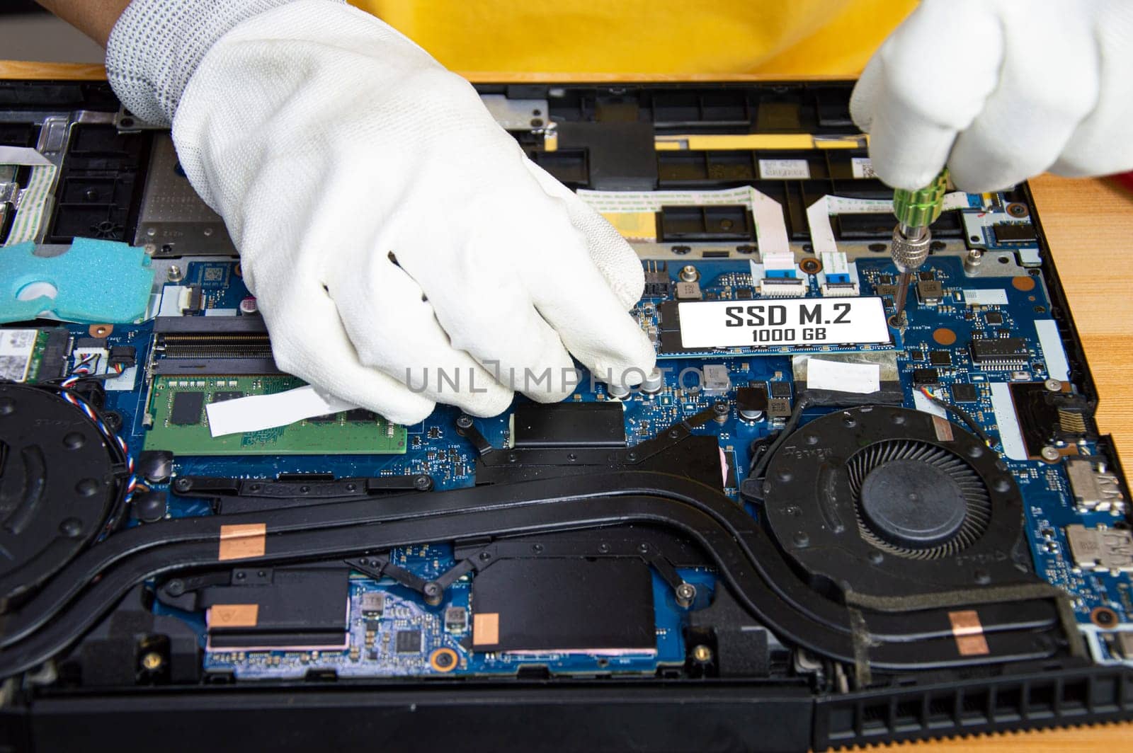 Top view of mechanic repairing computer, installing M.2 SSD