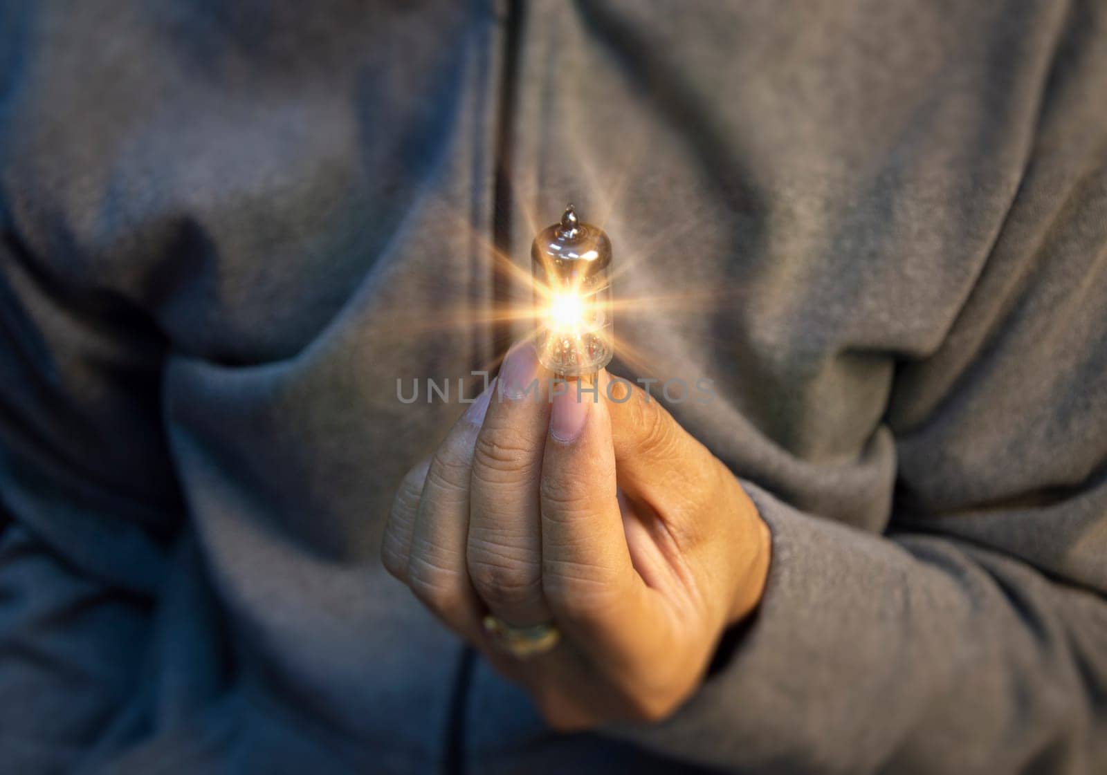 Human hand holding light bulb, idea, innovation and inspiration with glowing virtual brain, smart creativity with light bulb, motivation and innovation concept by boonruen