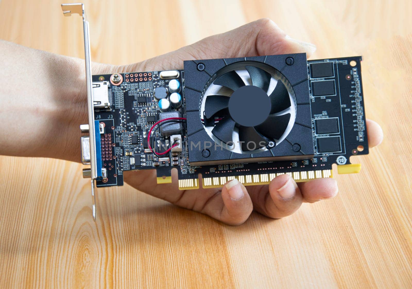 side view of computer graphics card holding in hand by boonruen