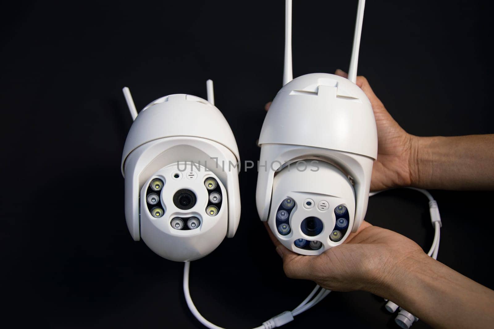 Two white IP cameras placed on a black background by boonruen