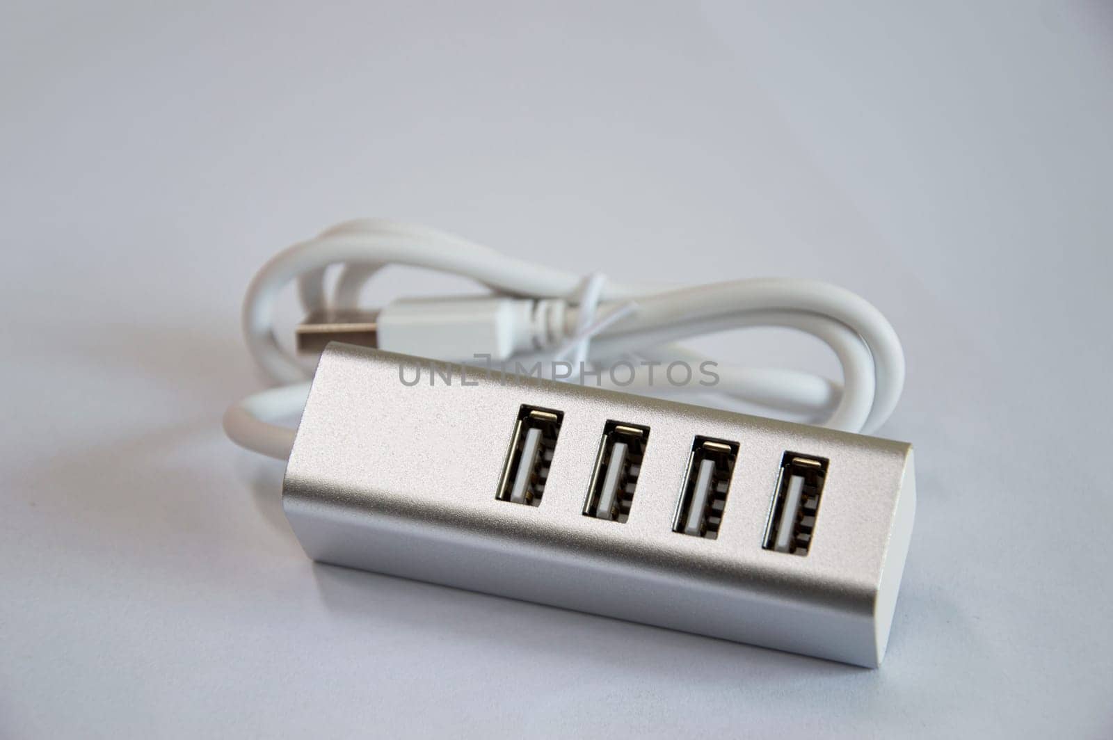 USB hub with 4 ports, silver, placed on a white background by boonruen