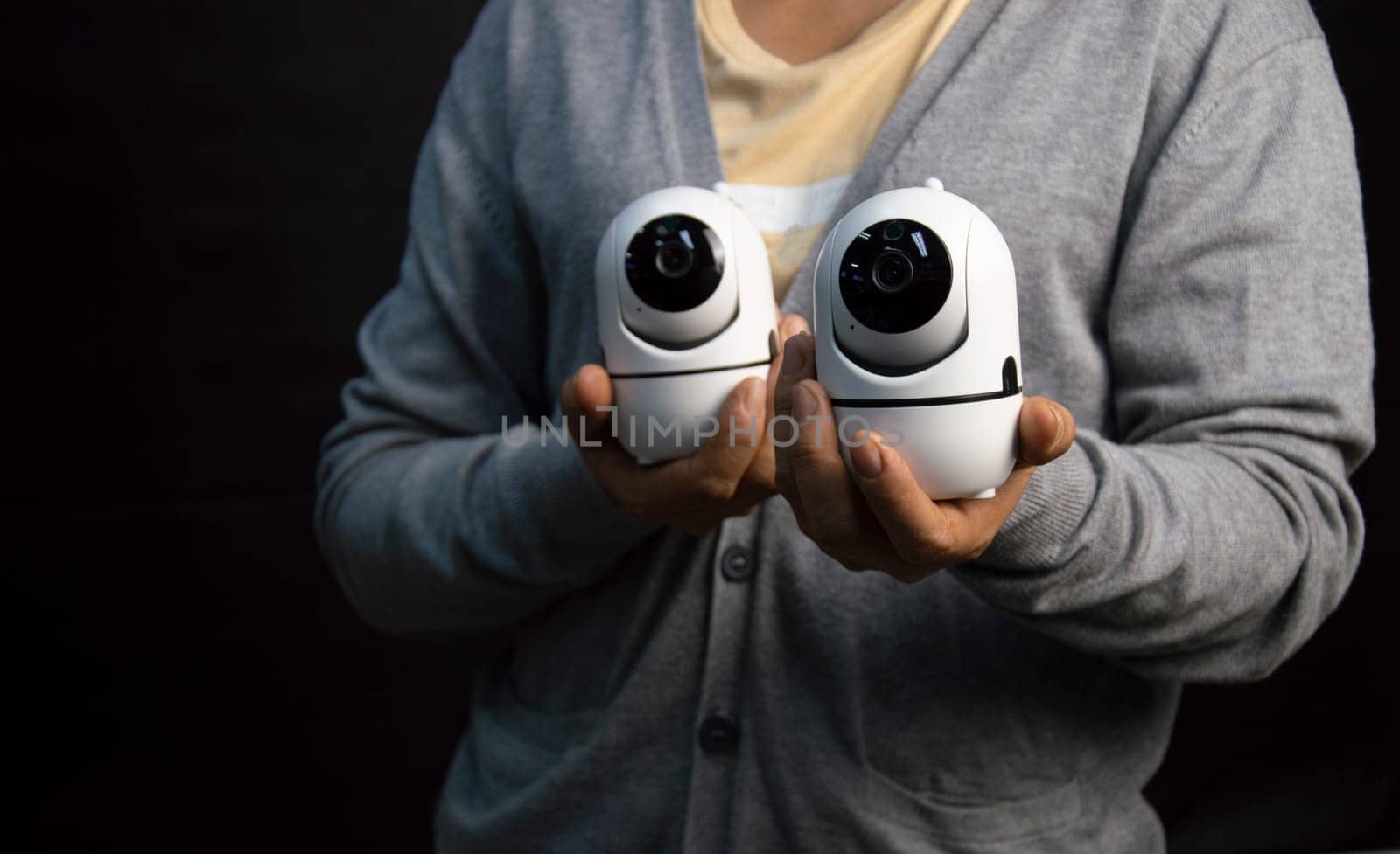 Woman holding white IP camera. Very popular for security purposes.