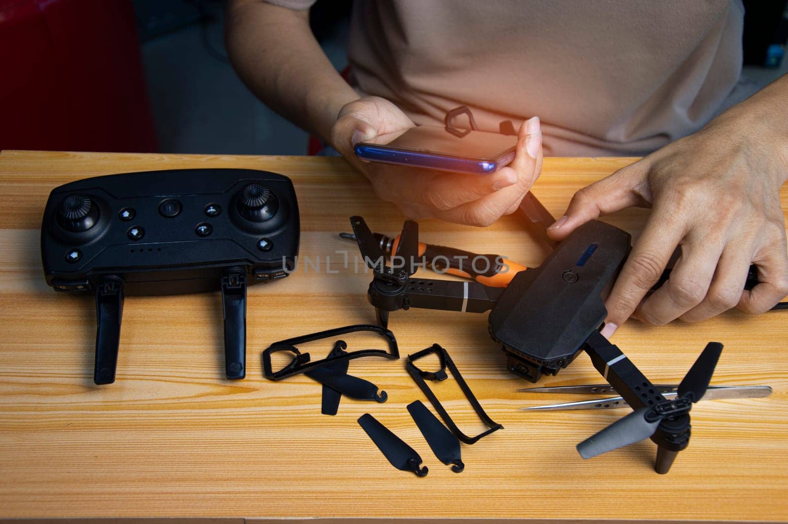 Professional mechanic repairing a drone, setting it up, on a table with various tools. in modern workshop