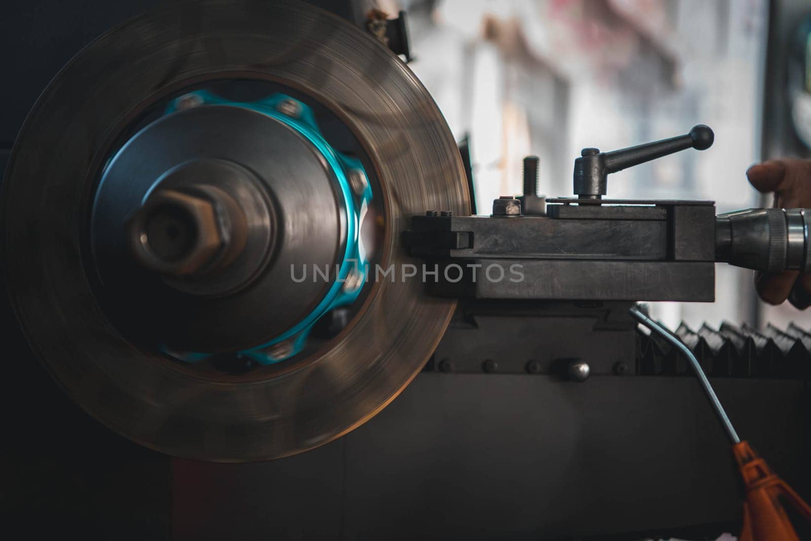 Car mechanic or serviceman disassembly and checking a disc brake and asbestos brake pads for fix and repair problem at car garage or repair shop