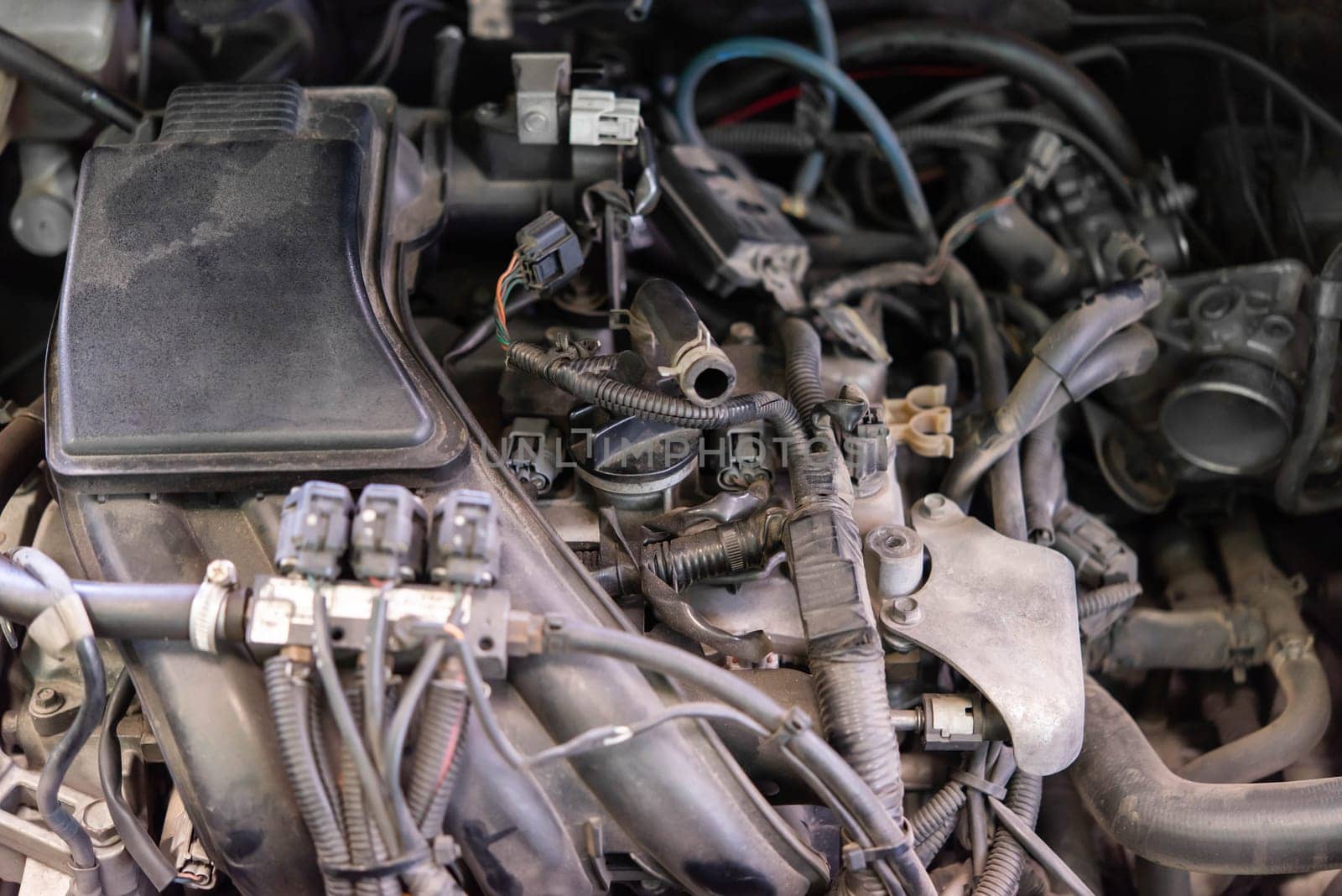 Car mechanic drain the old lubricant engine oil at car garage for changing the oil in a car engine