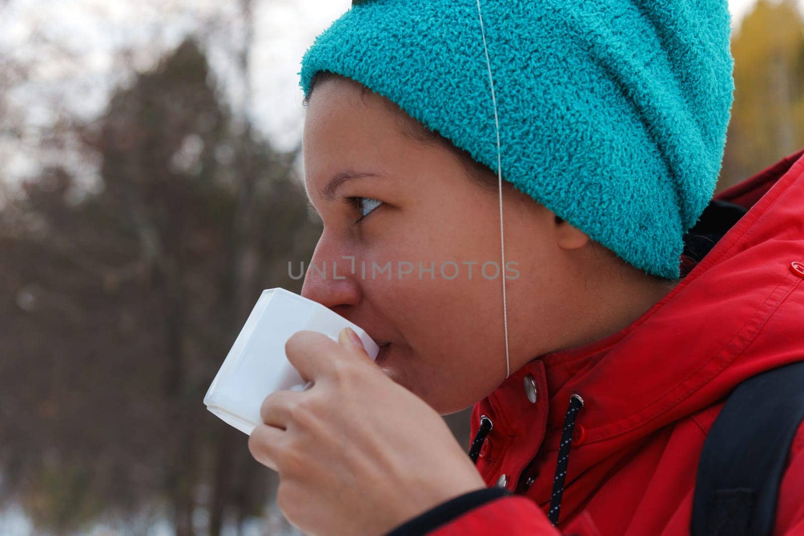 Celebrating friendship in a snowy forest with warm drinks and playful hats during a winter gathering
