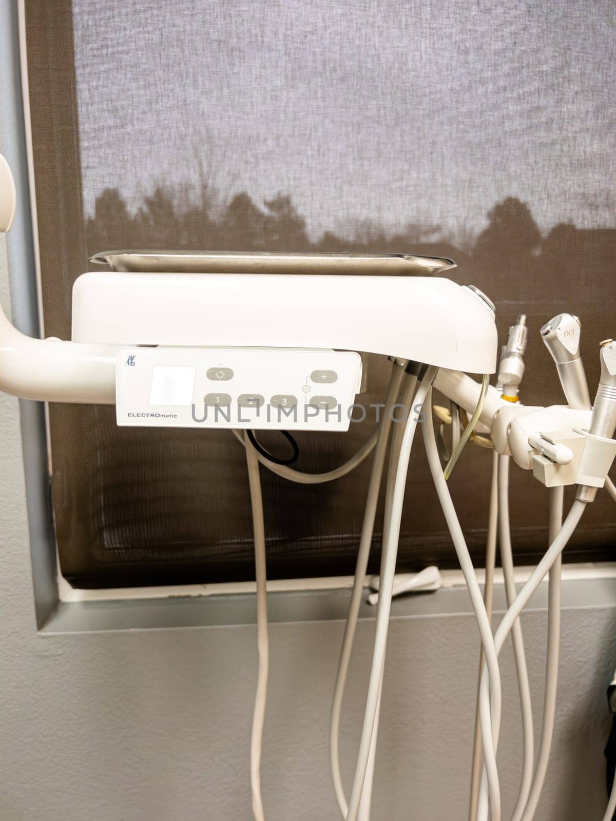 Denver, Colorado, USA-January 11, 2024-Close-up view of advanced dental office equipment, possibly an ultrasonic cleaner or other sterilization unit, set against a stainless-steel backdrop. It features a prominent digital interface and is connected by various tubes and cords, suggesting its role in patient care procedures.