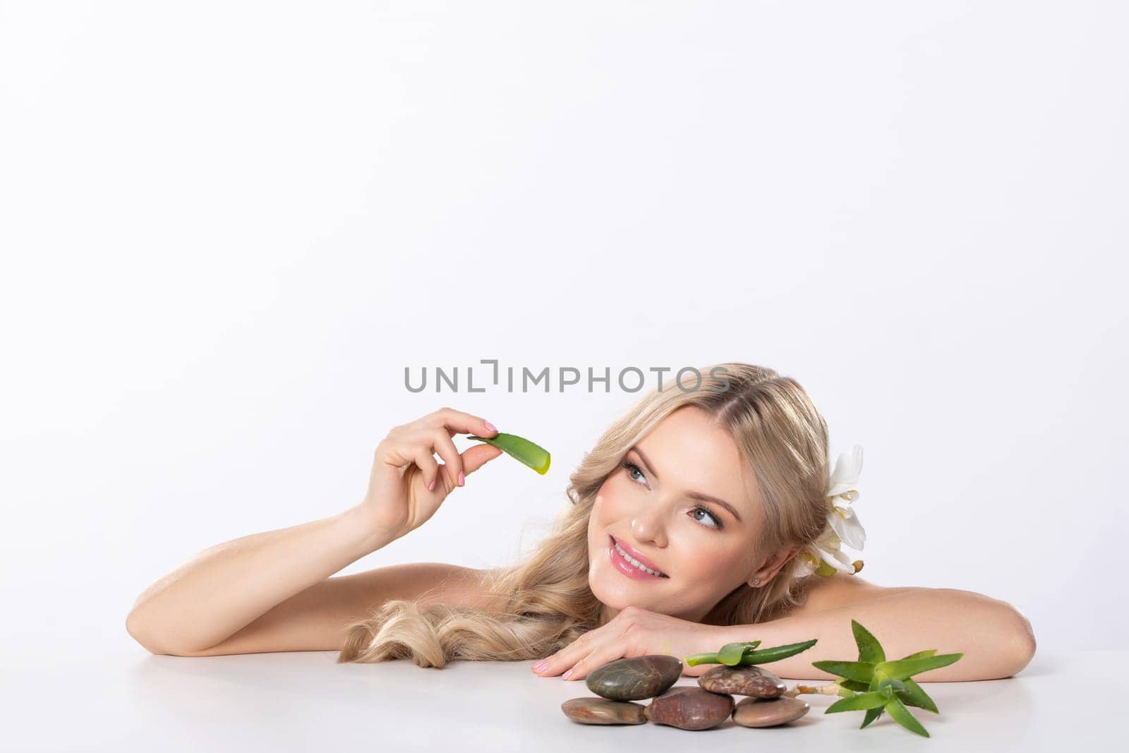 A tranquil woman gracefully positioned among lush leaves and smooth stones, beautifully embodying natures elegance