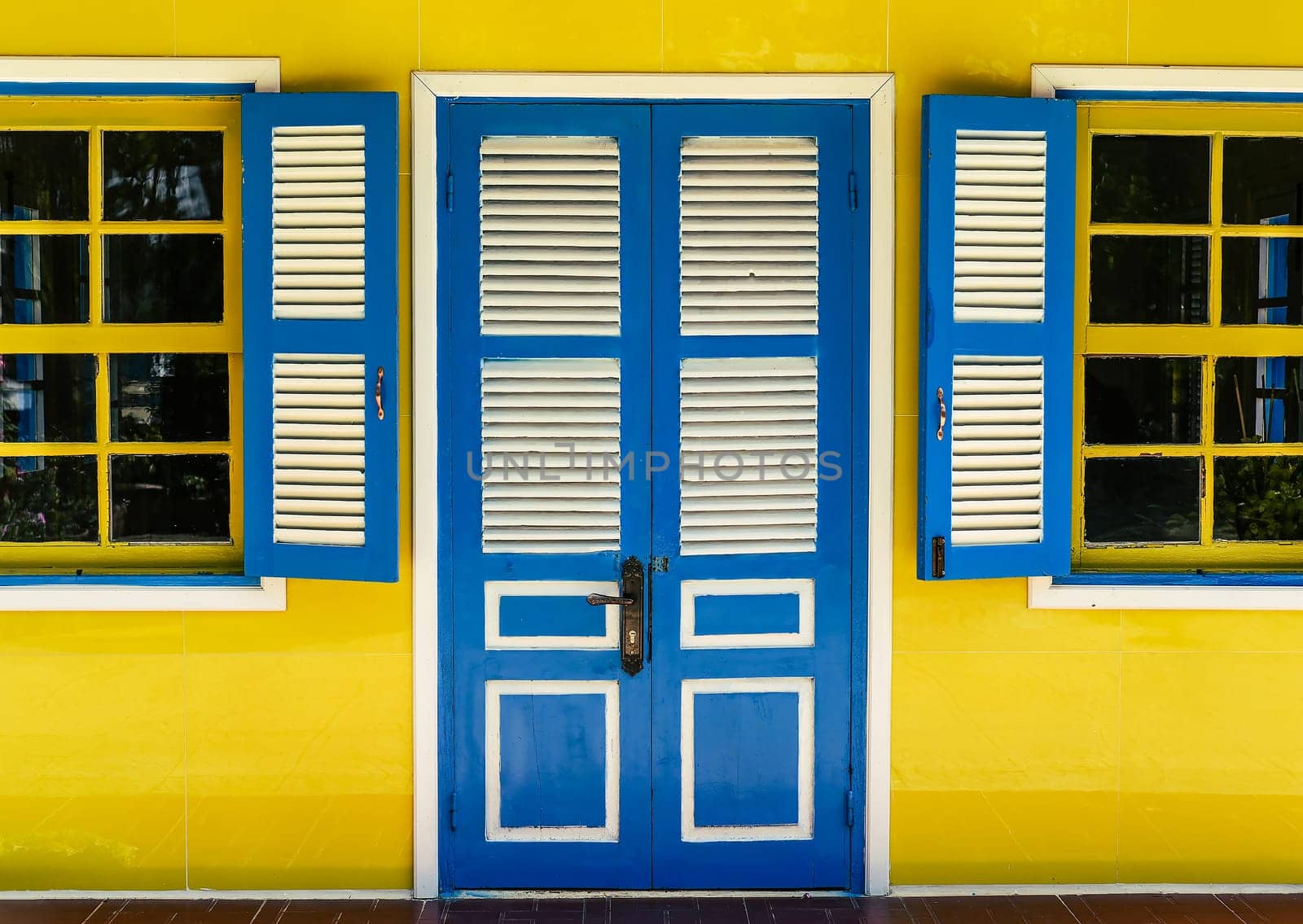 Closed wooden door and opened windows in positive colors
