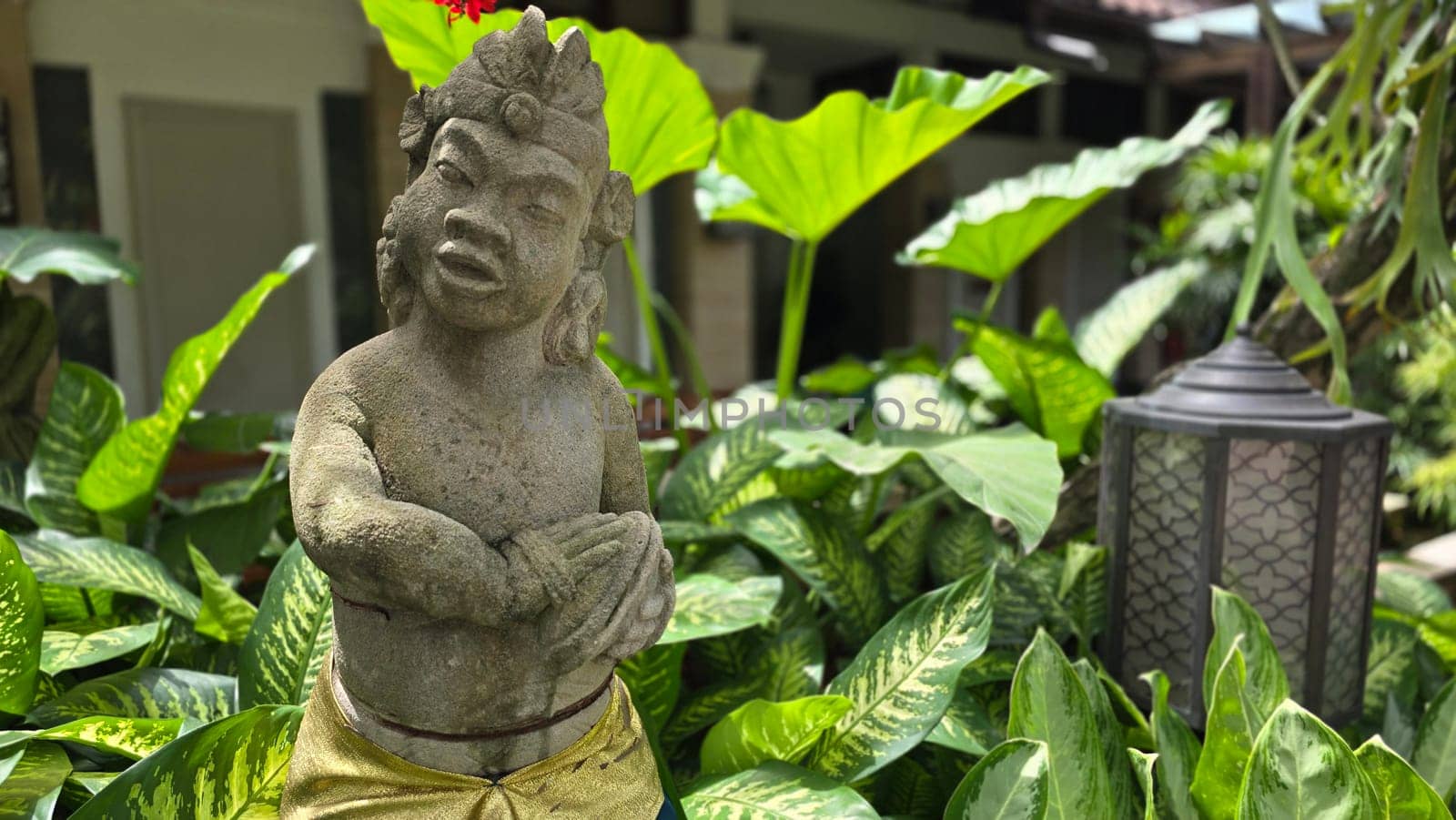 Garden Gnome traditional stone statue situated in a tranquil tropical garden, surrounded by vibrant foliage and artistic decor, harmonizing with the natural beauty of its environment. Good for Background