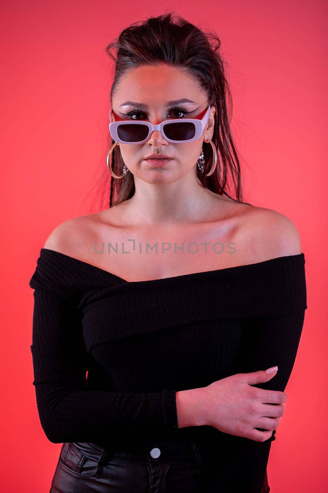 A stylish and fashionable woman confidently wearing chic sunglasses, showcasing her trendy style and bold attitude